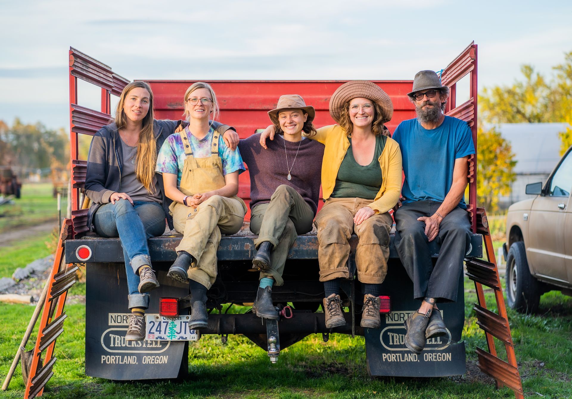 A group of people are sitting on the back of a truck.