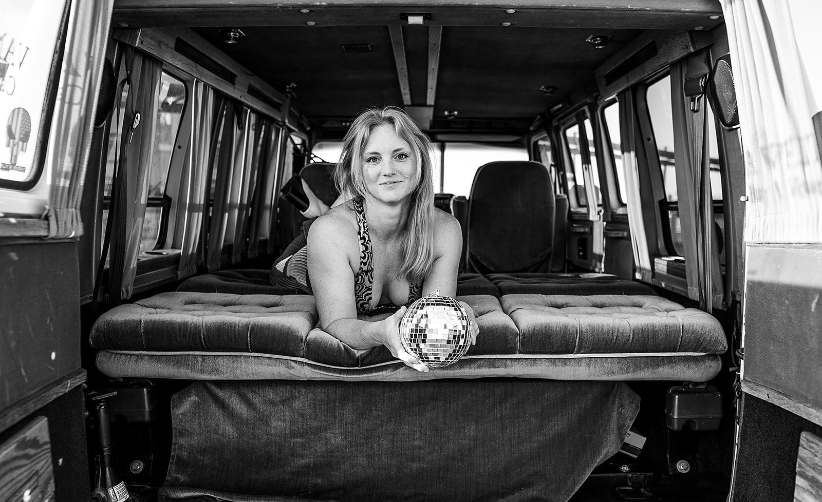 A woman is laying in the back of a van.