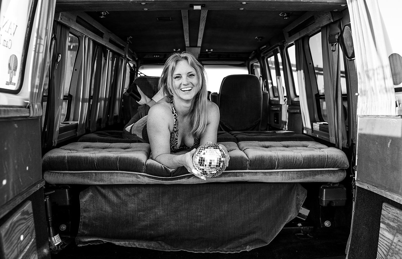 A woman is laying in the back of a van.