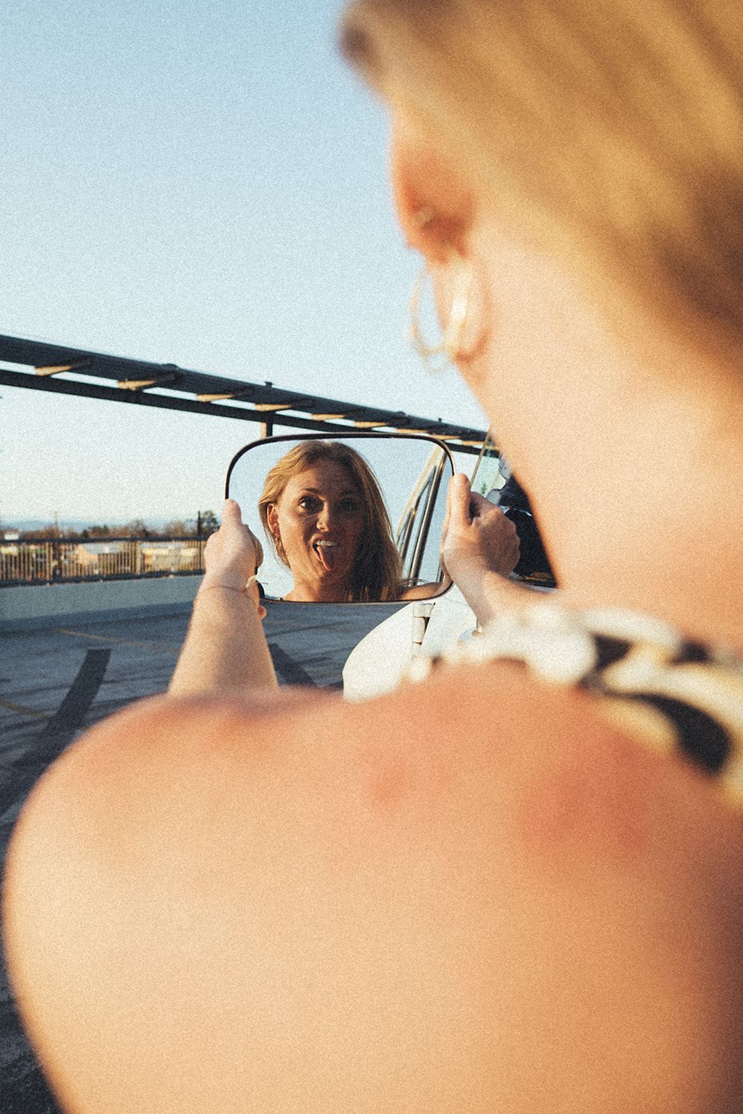 A woman is looking at her reflection in a mirror and giving a thumbs up.