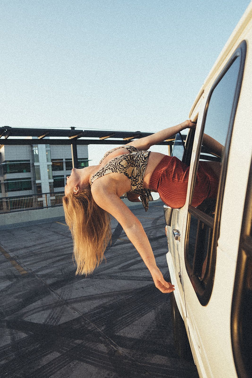 A woman is leaning out the window of a van.