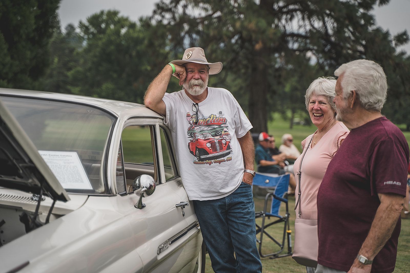A man in a cowboy hat is standing next to a white truck.