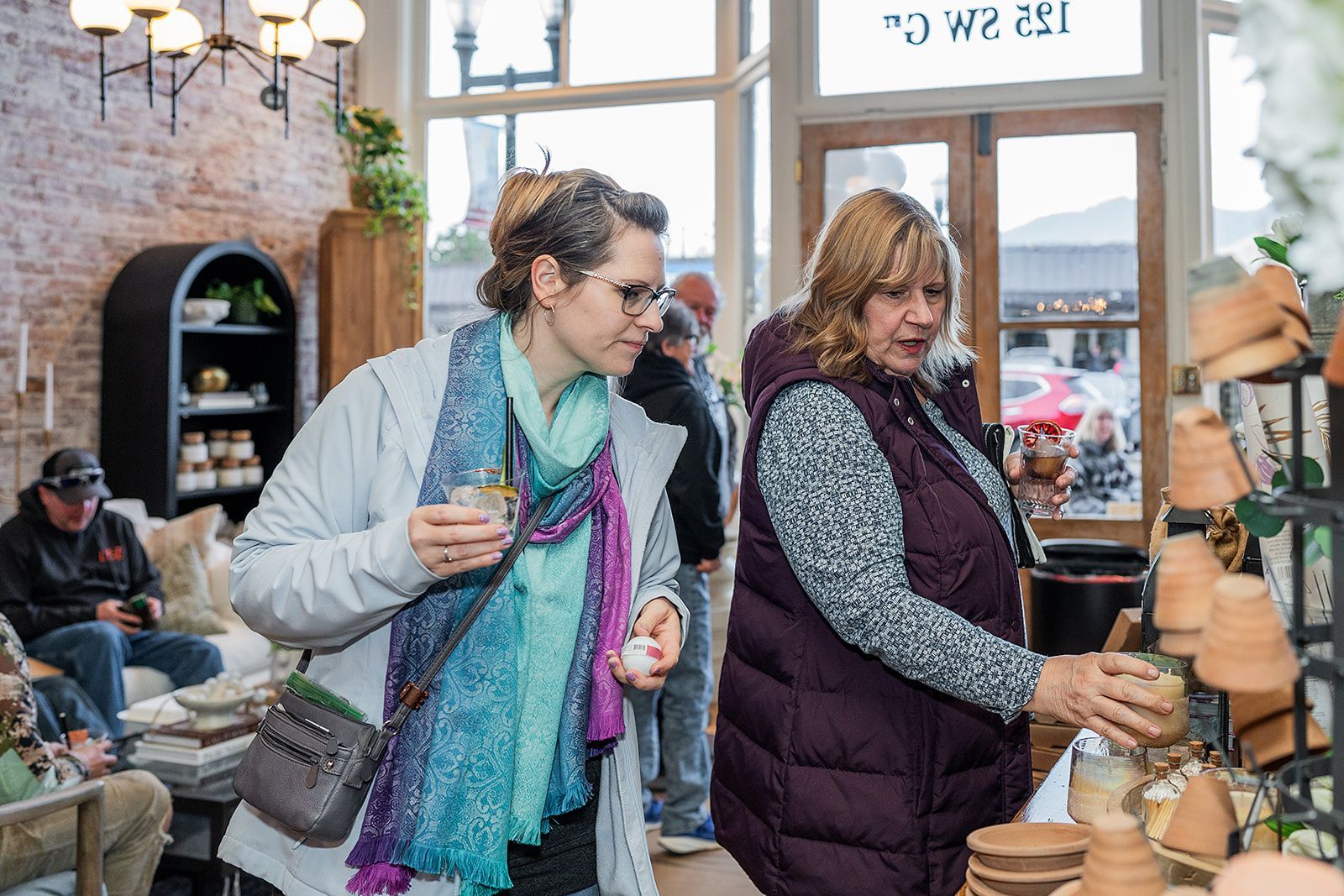 Two women are looking at pots in a store.