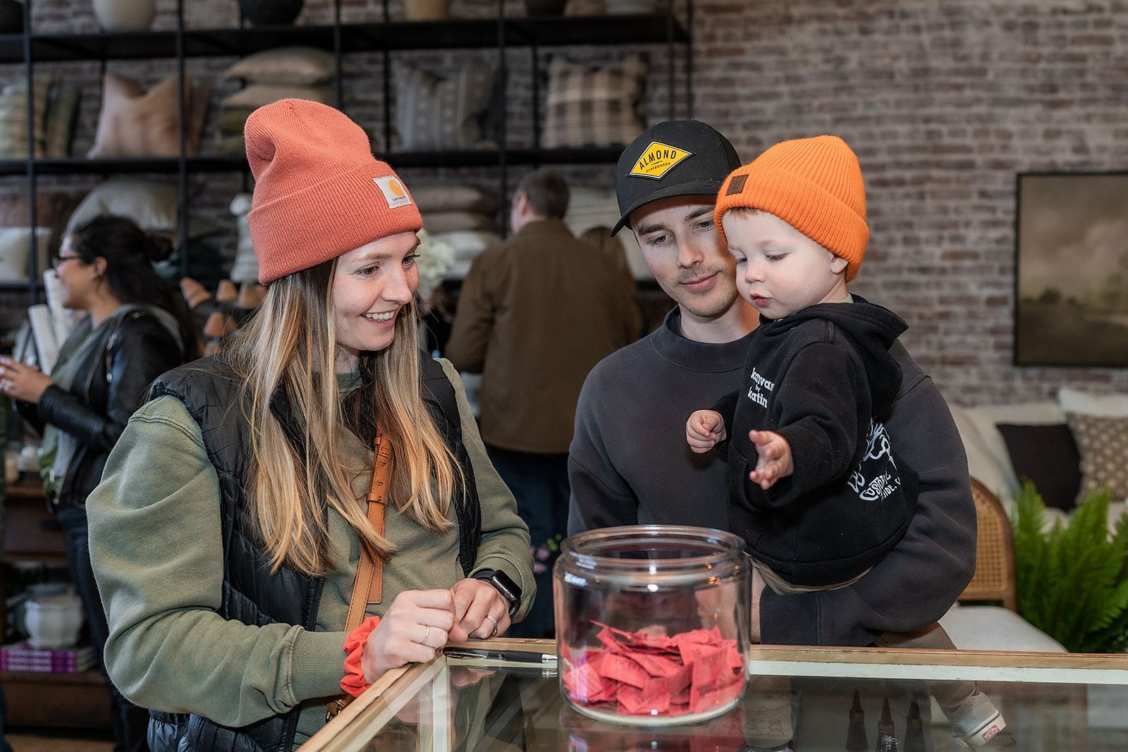 A man and a woman are holding a baby in a store.