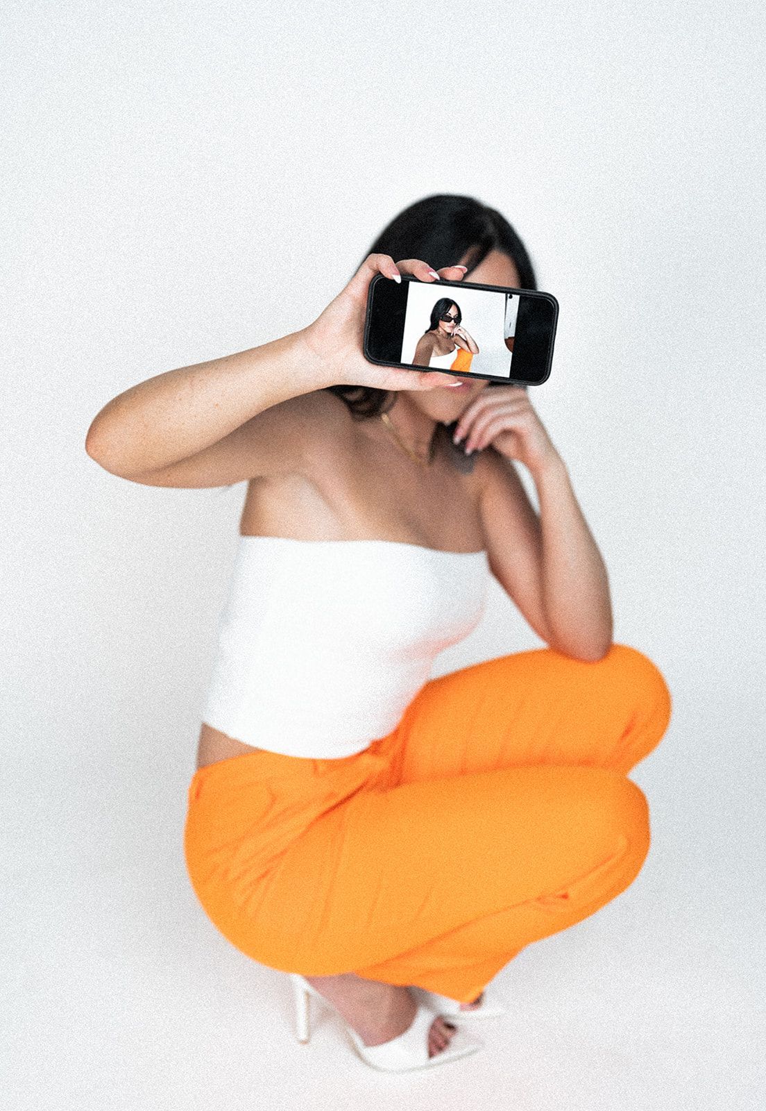 A woman is taking a picture of herself with her cell phone.