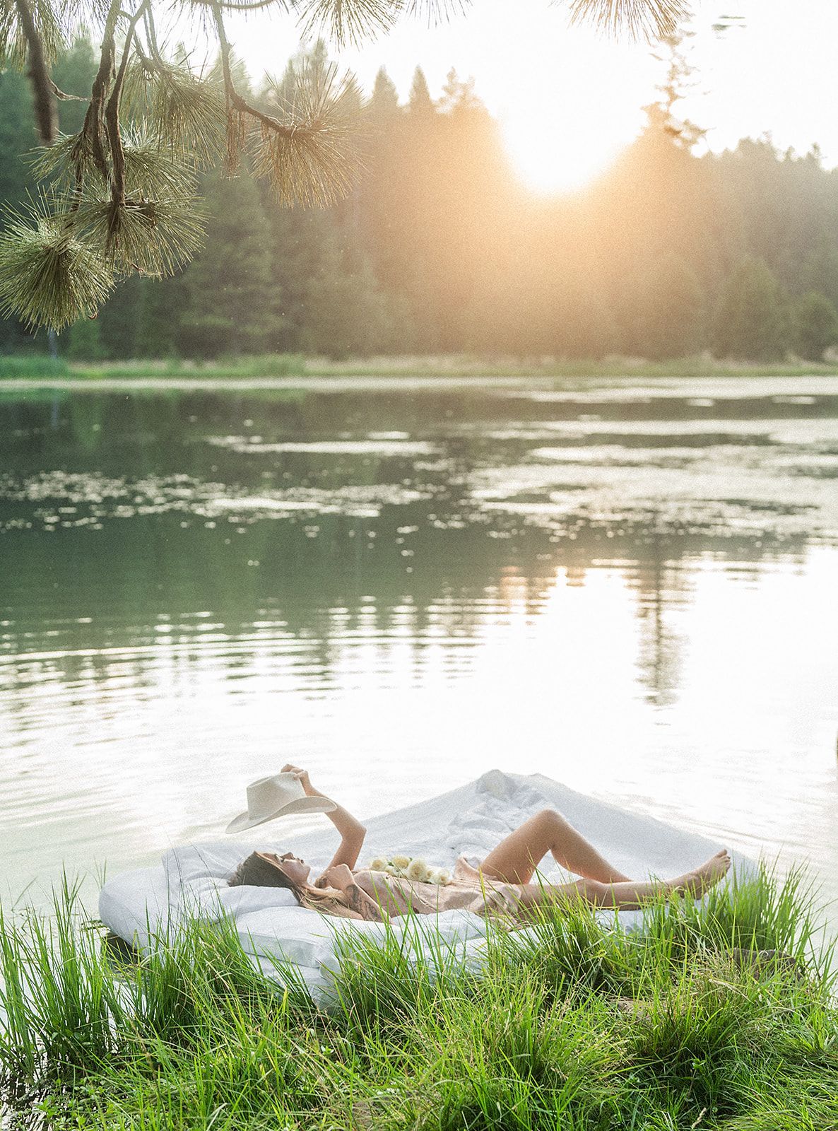 A woman is laying on a raft in the water reading a book.