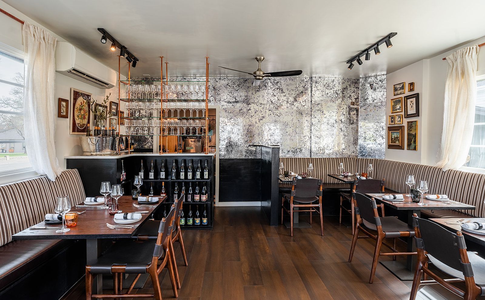 A restaurant with tables and chairs and a bar.