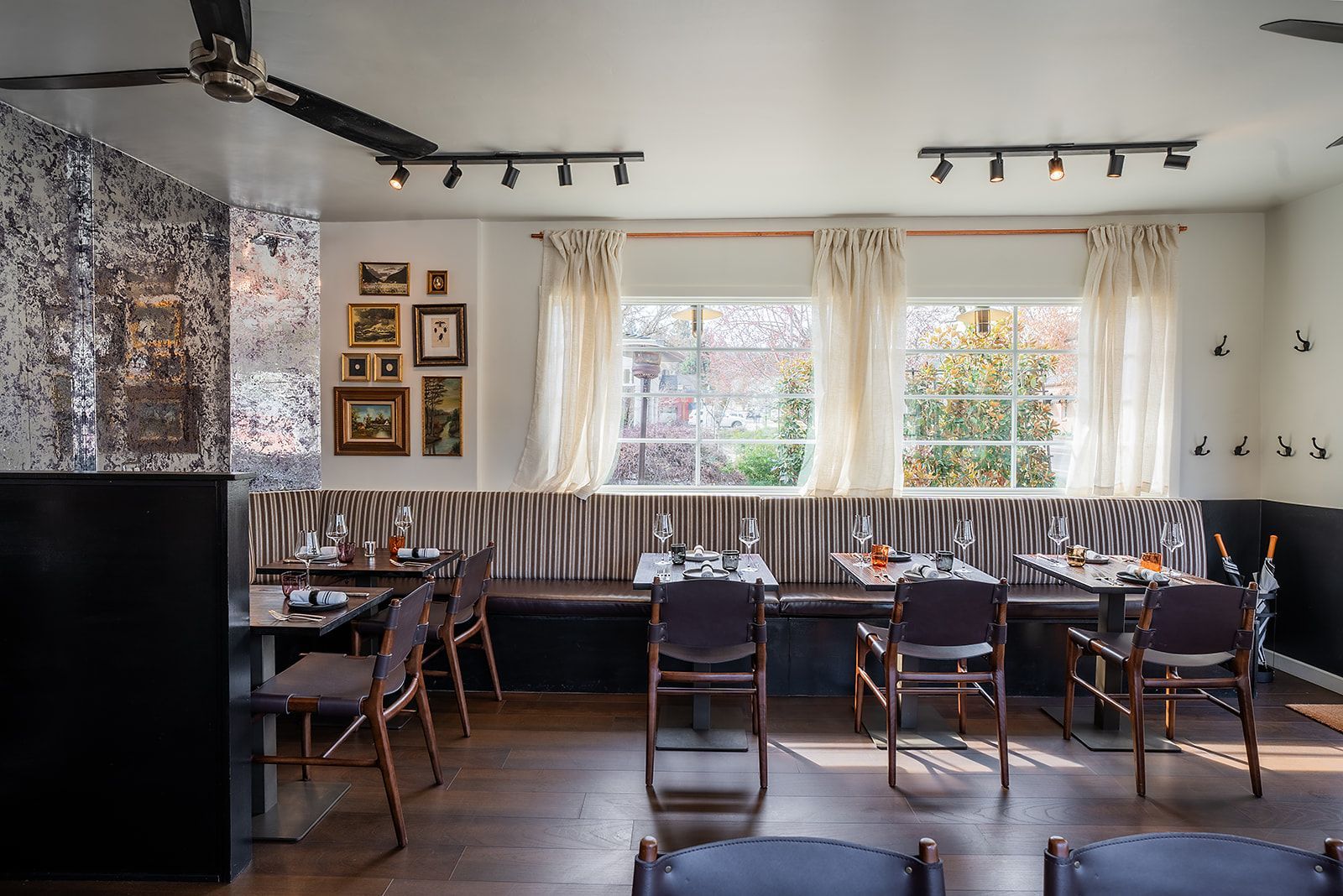 A restaurant with tables and chairs and a ceiling fan.
