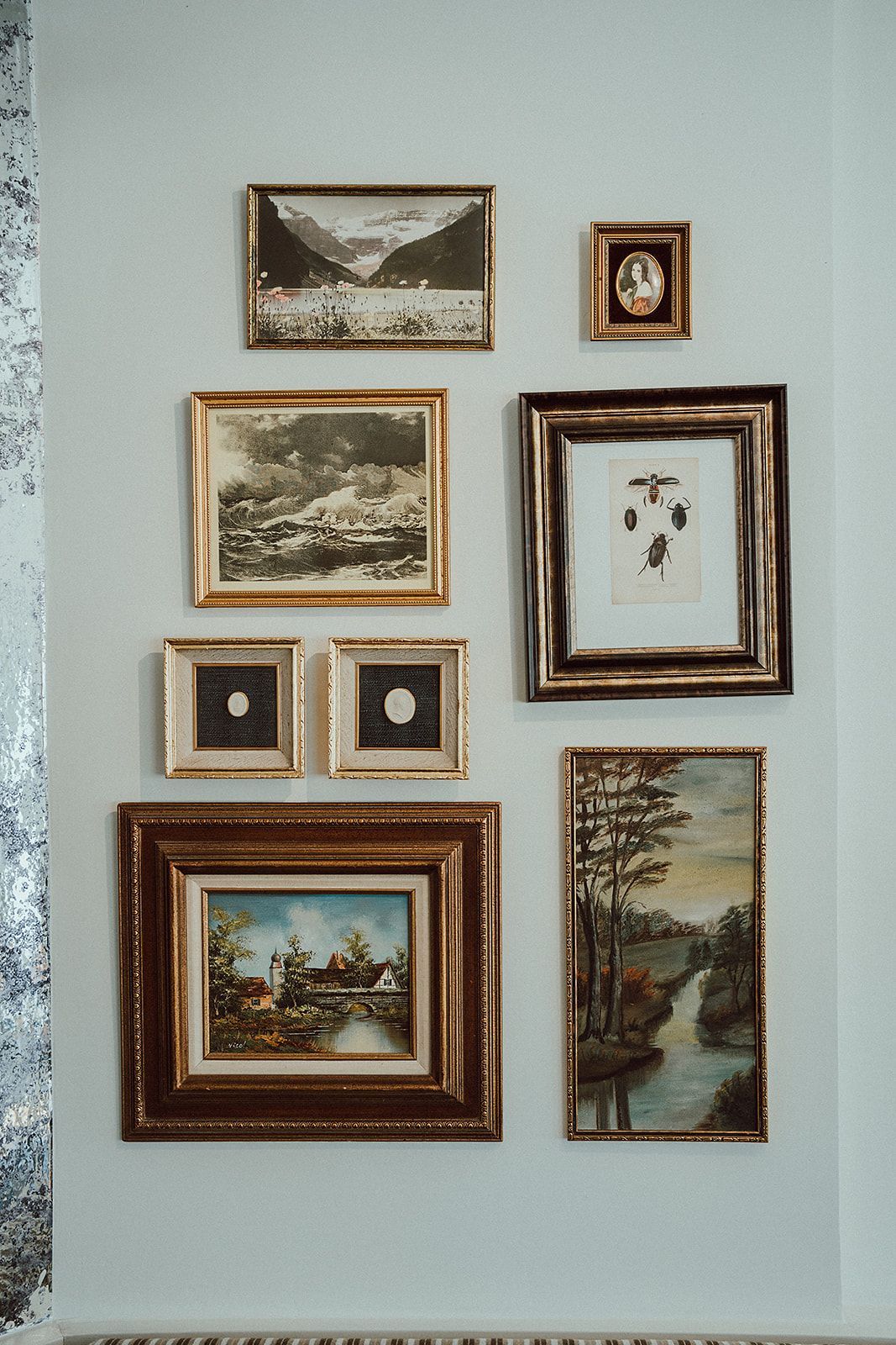 A wall with a bunch of framed pictures on it.