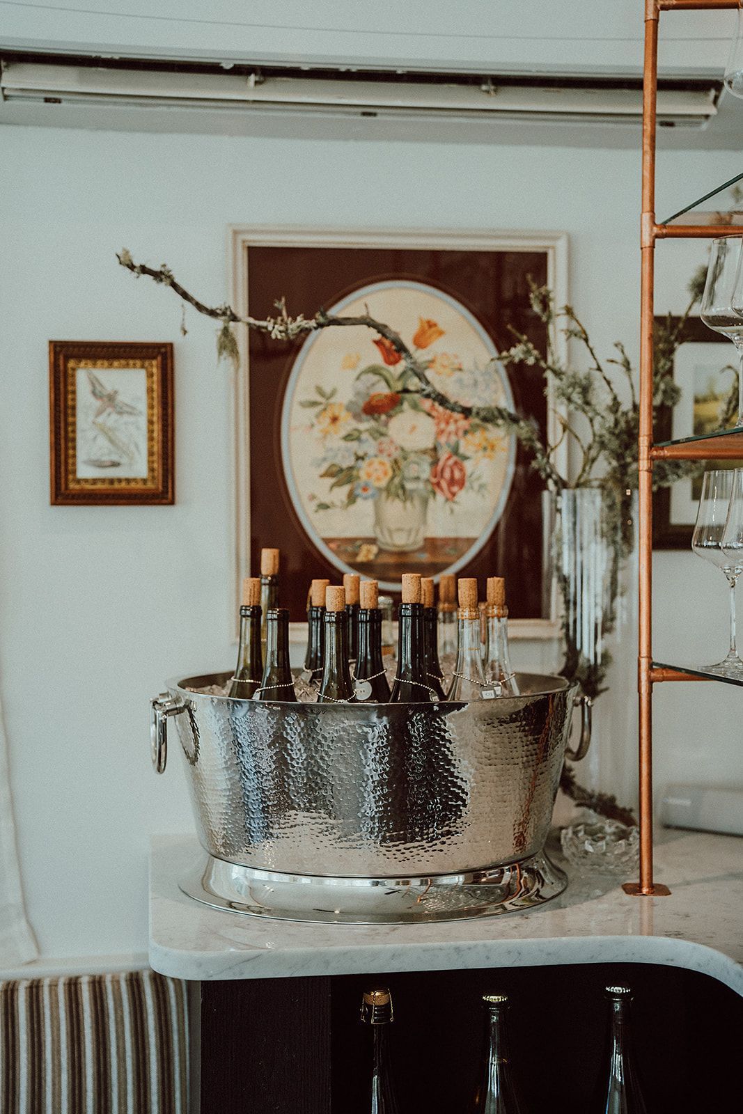 A bucket filled with bottles of wine is on a counter in a room.