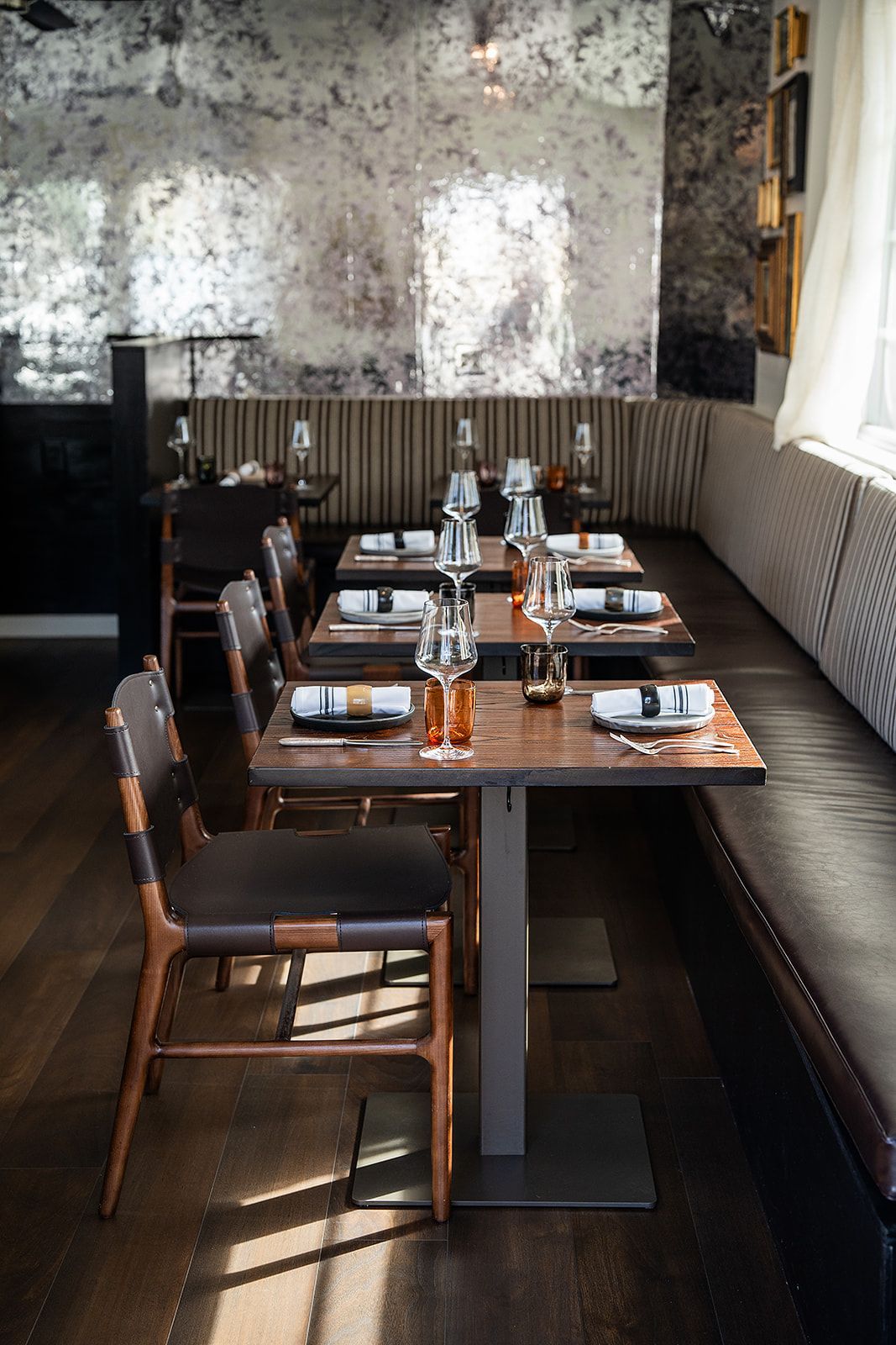 A restaurant with tables and chairs set up for a meal.