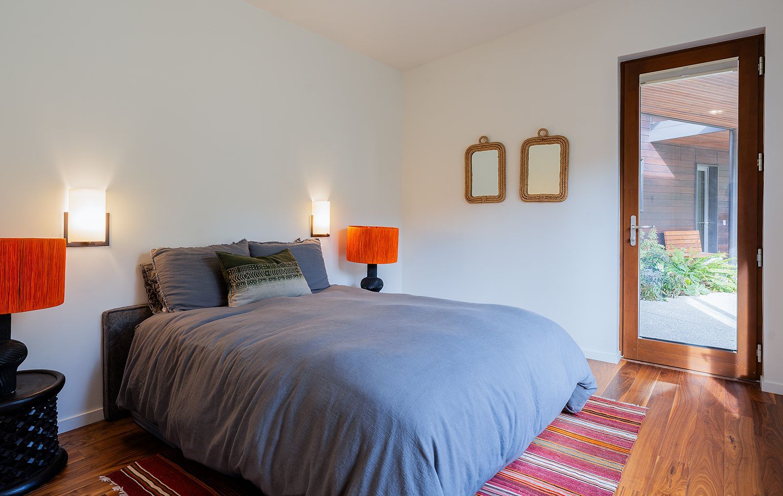 A bedroom with a large bed and two lamps