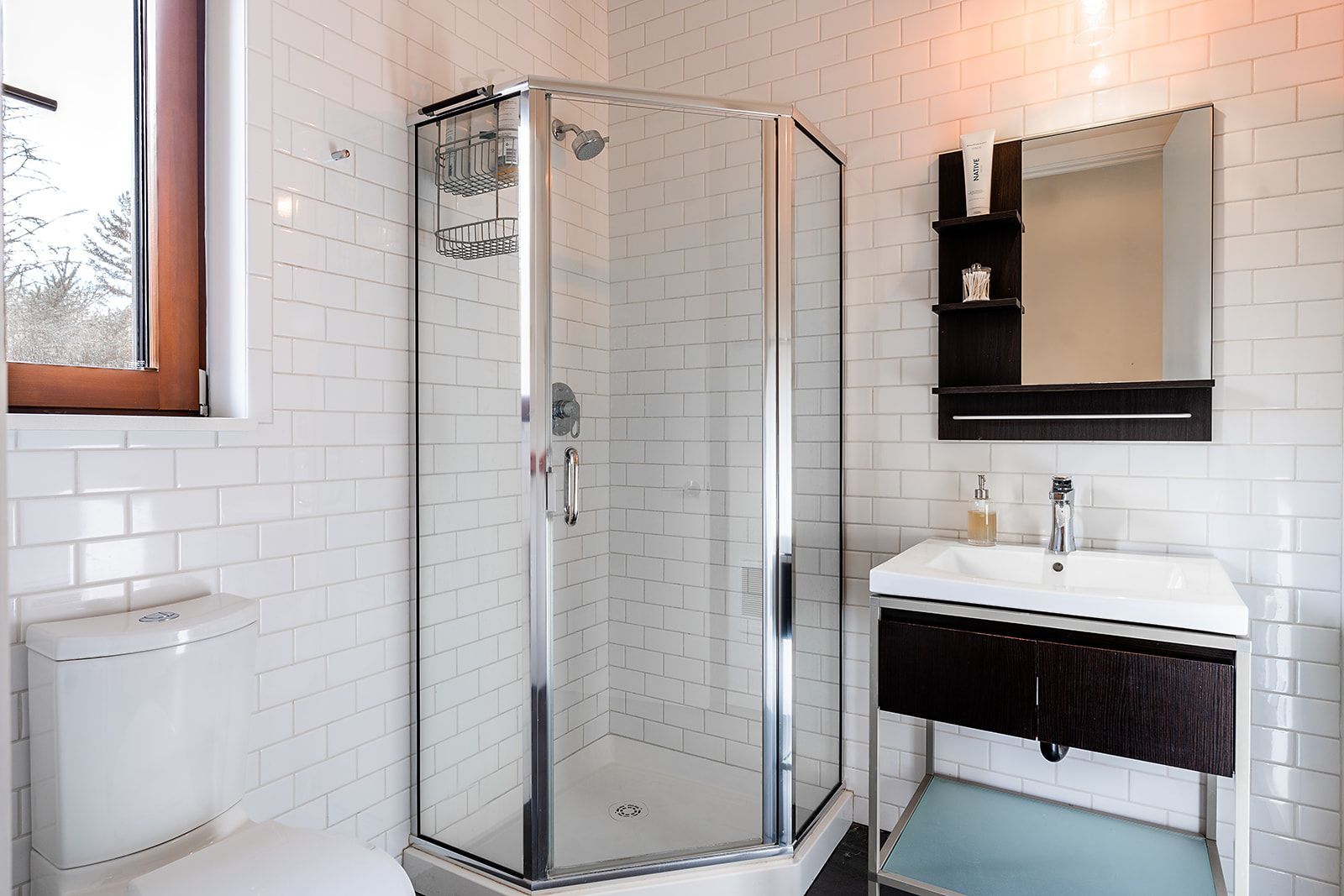 A bathroom with a toilet a sink and a shower stall