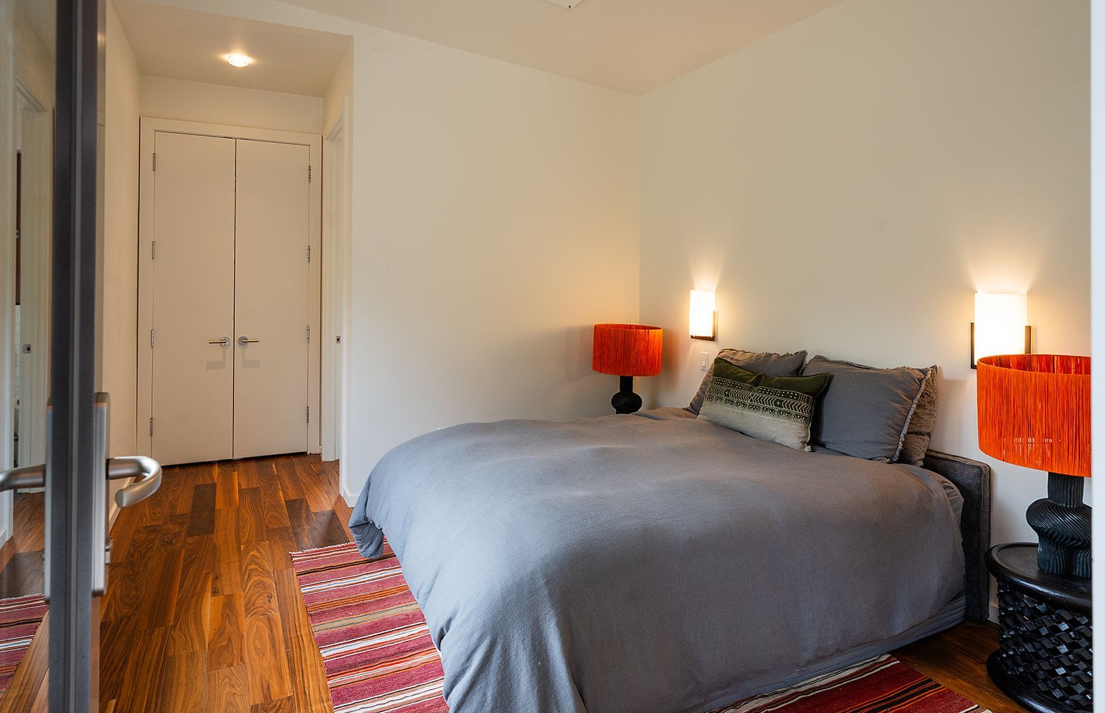 A bedroom with a large bed and two lamps