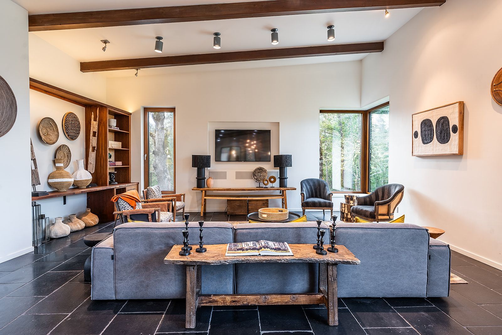 A living room with a couch , chairs , a table and a television.