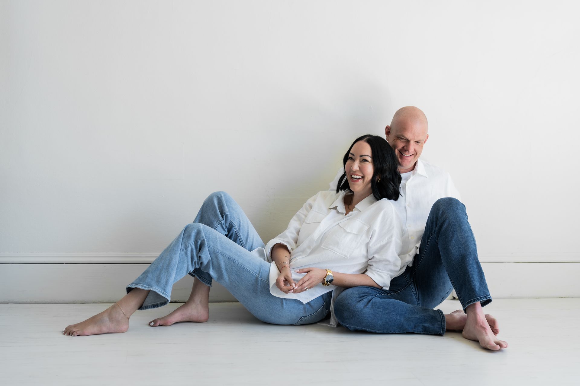 A man and a pregnant woman are sitting on the floor.