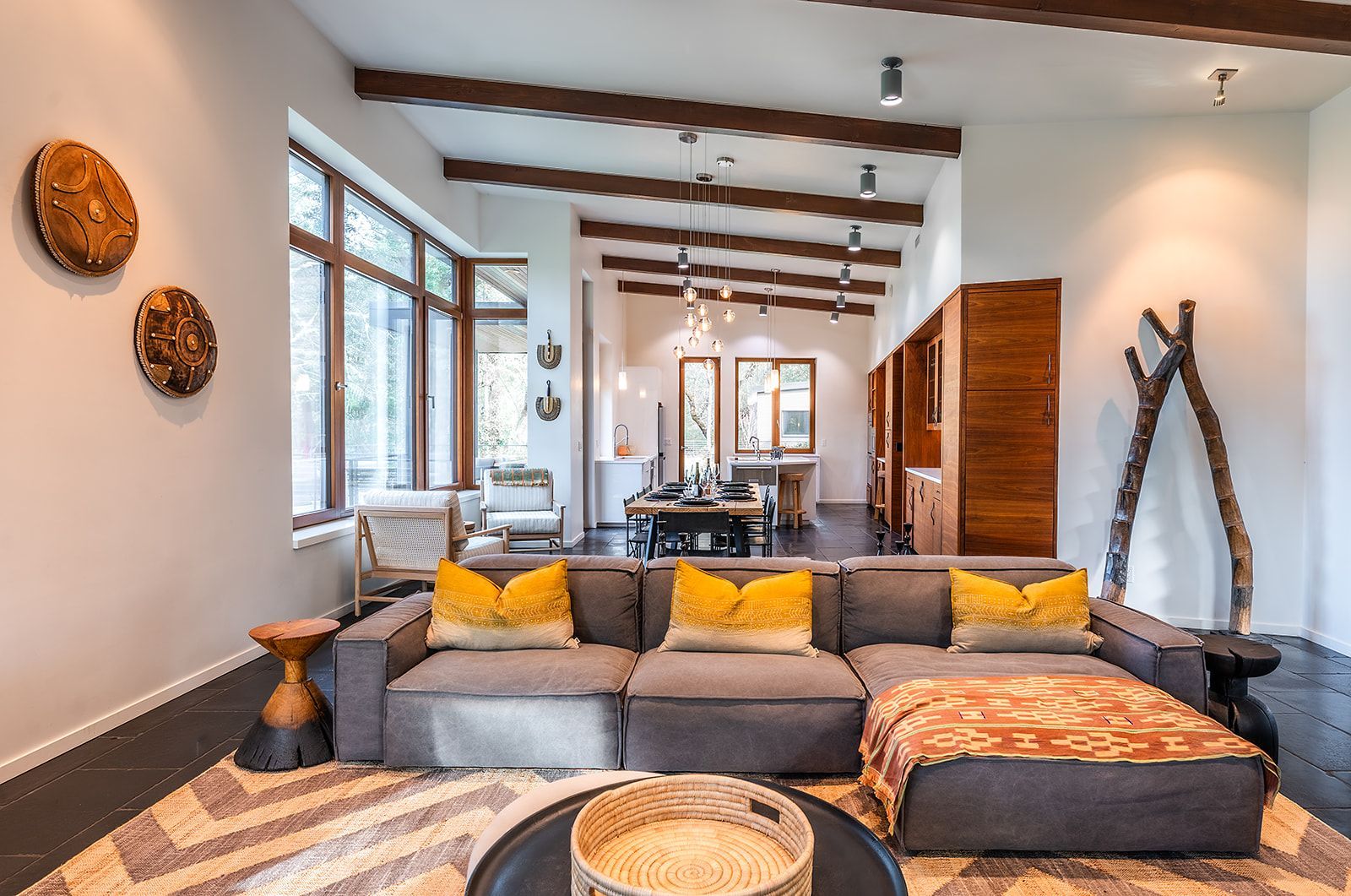 A living room with a couch , table , chairs and a rug.