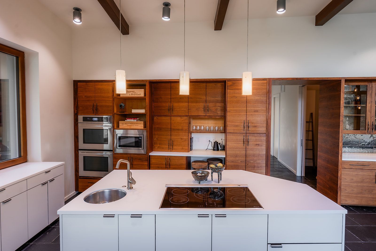 A kitchen with white cabinets , stainless steel appliances and a large island.