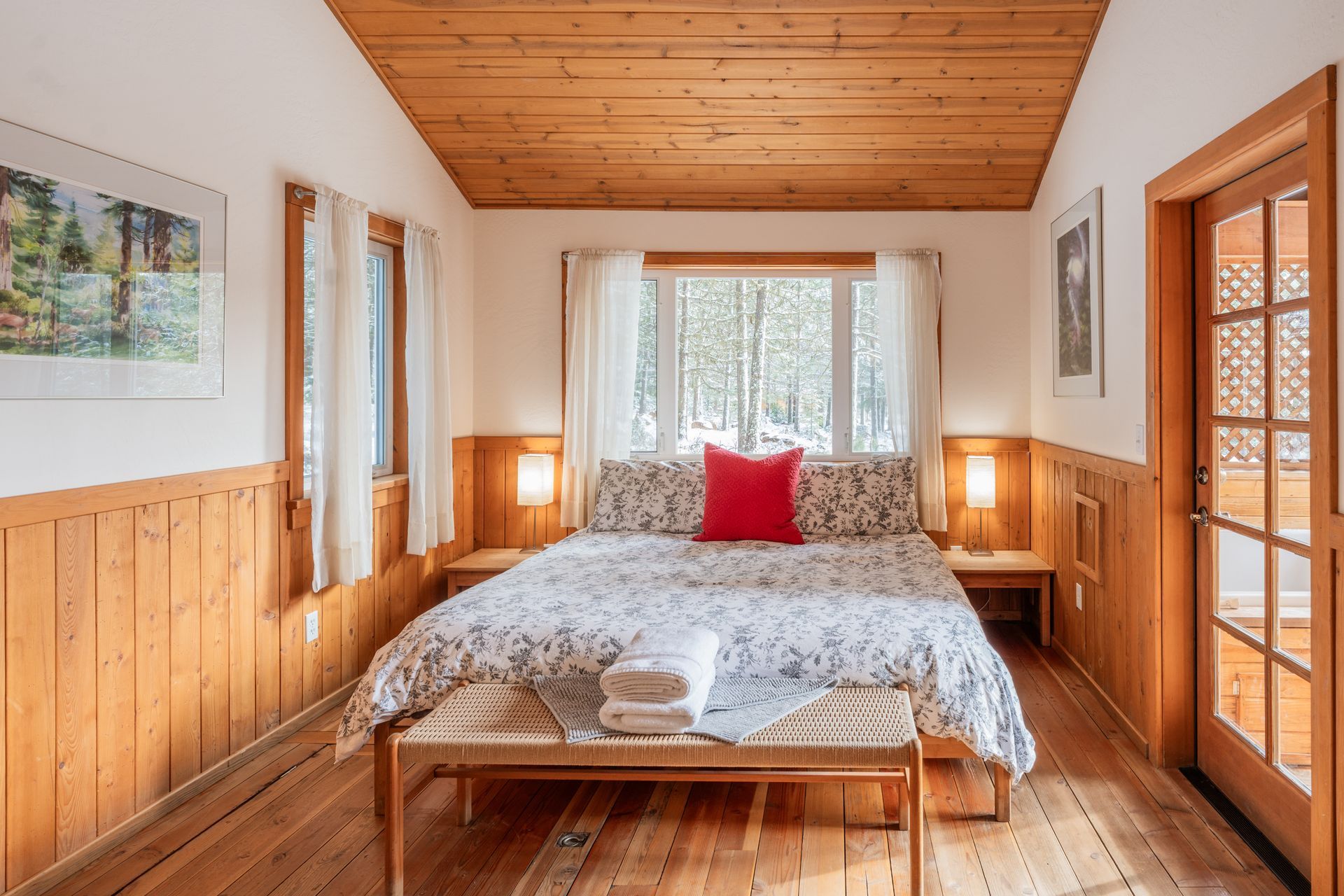 There is a bed in the middle of the room with a wooden ceiling.