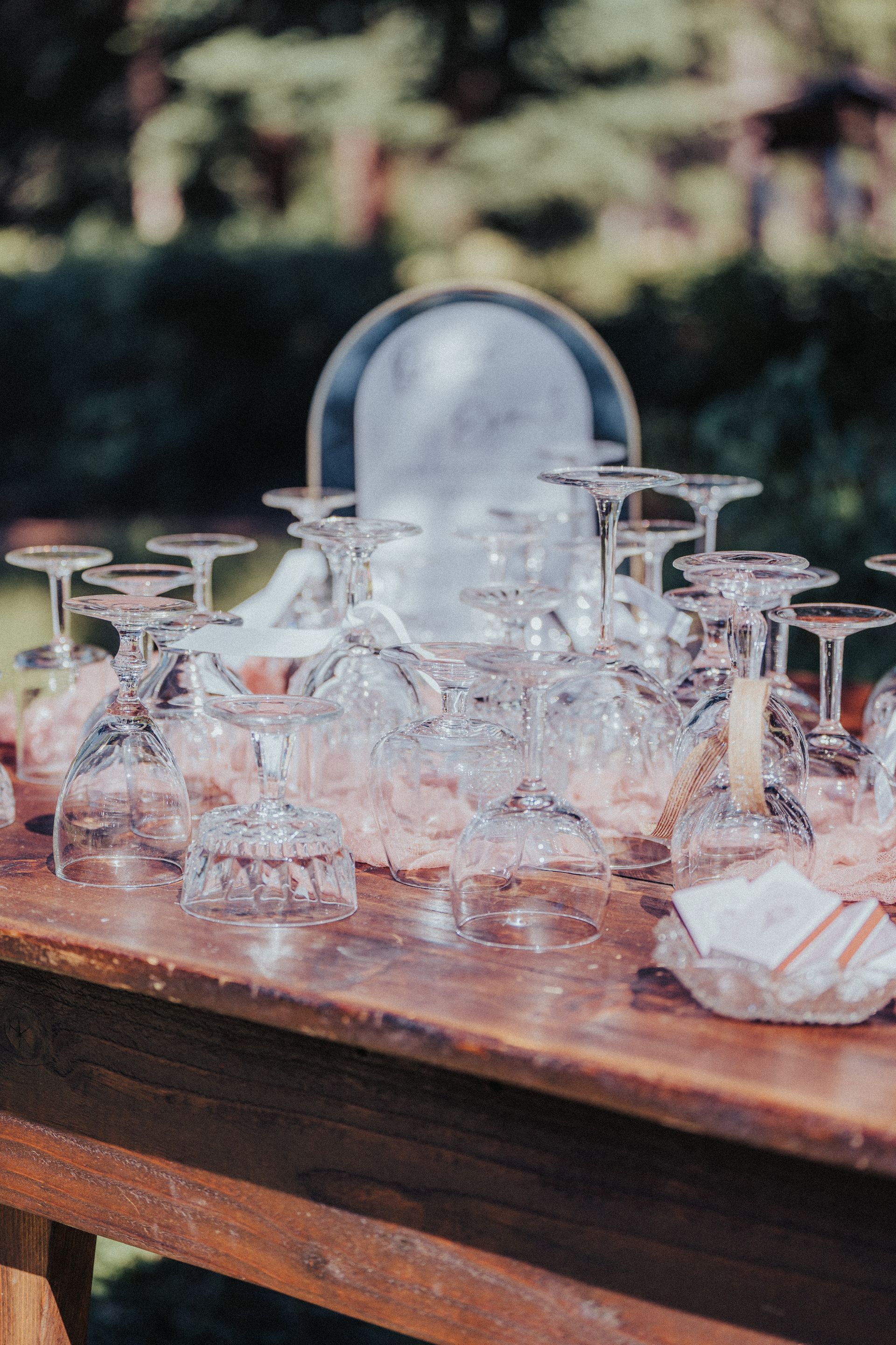 A bunch of wine glasses are sitting on a wooden table.