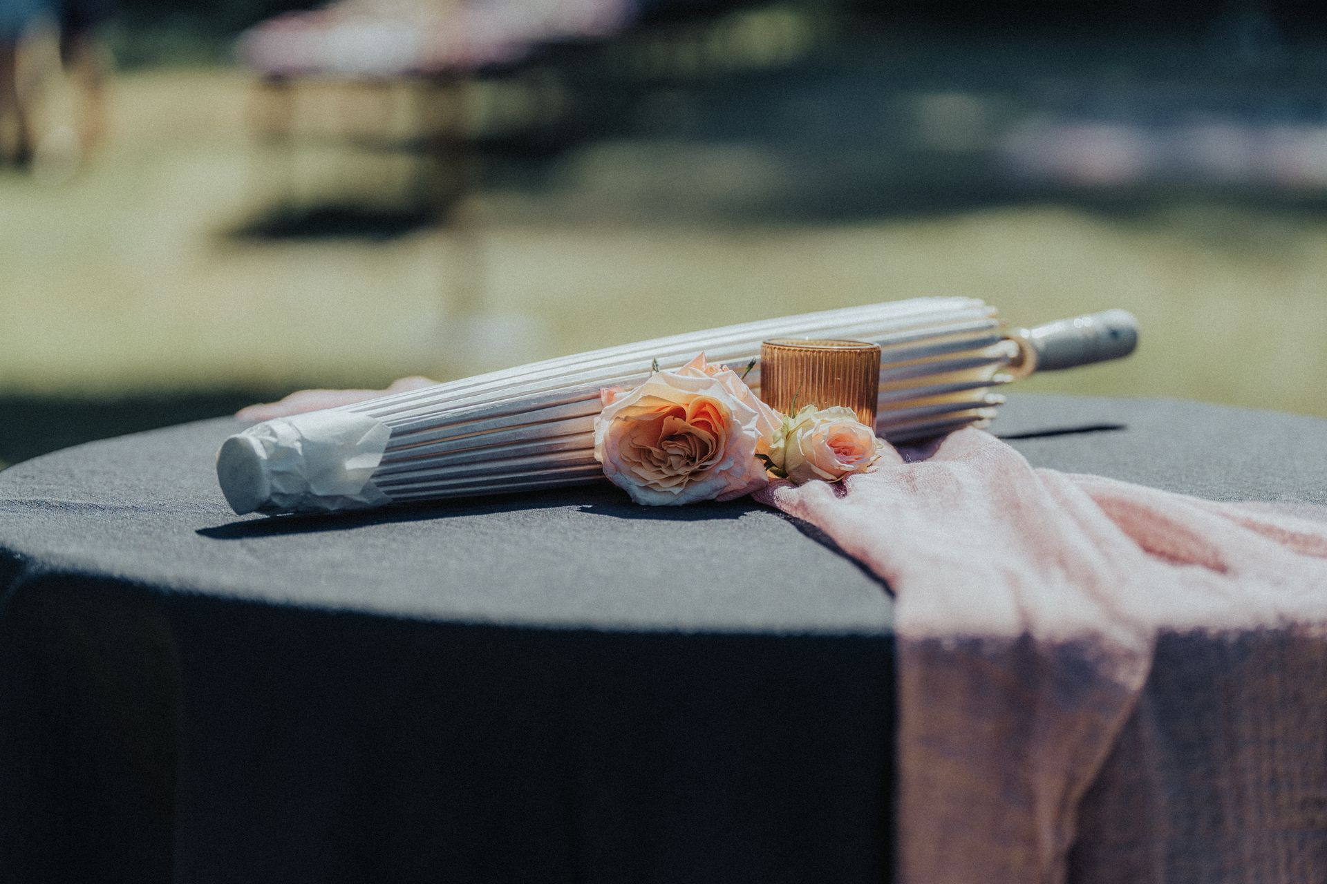 An umbrella and flowers are sitting on a table.
