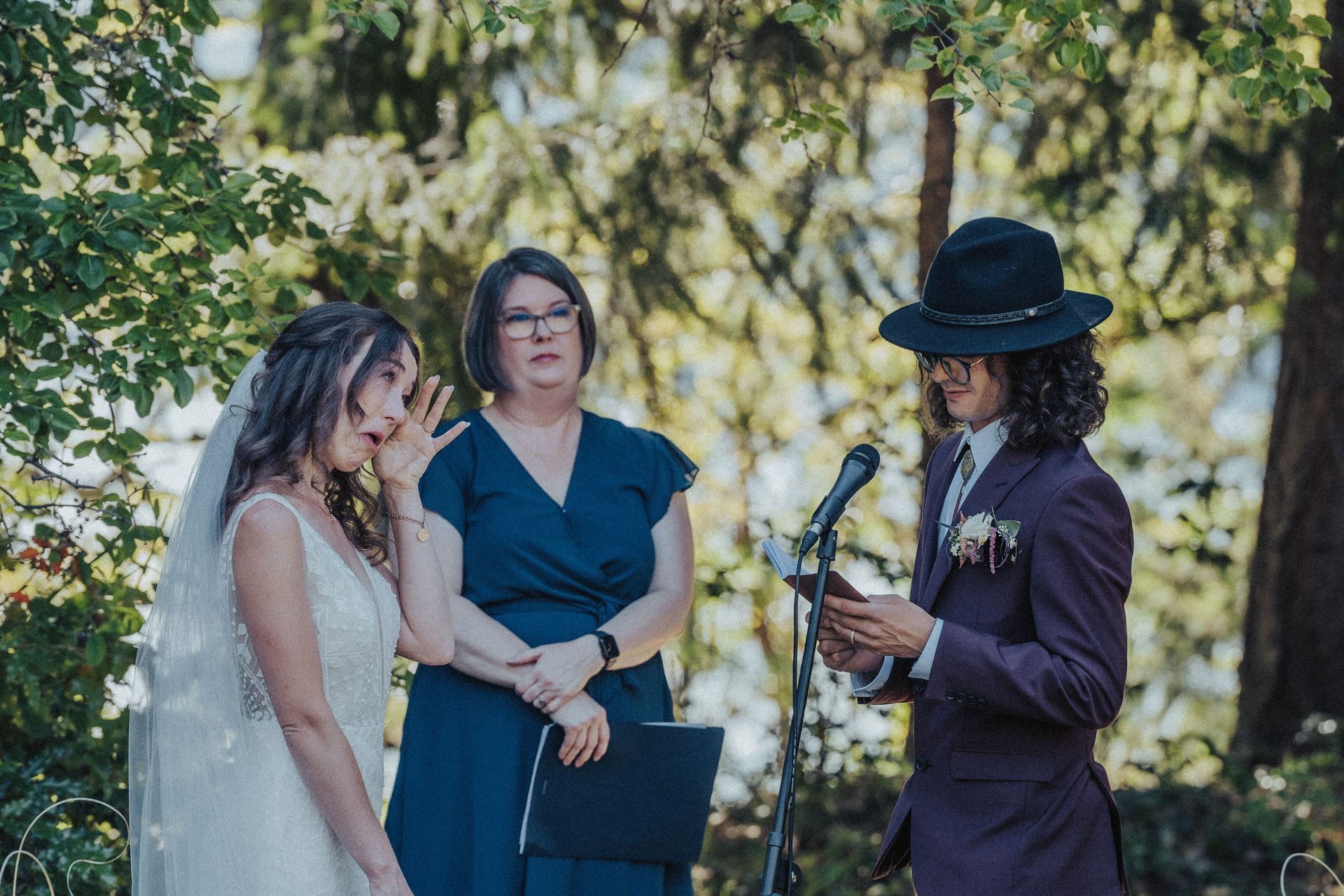 A bride and groom are getting married in the woods.