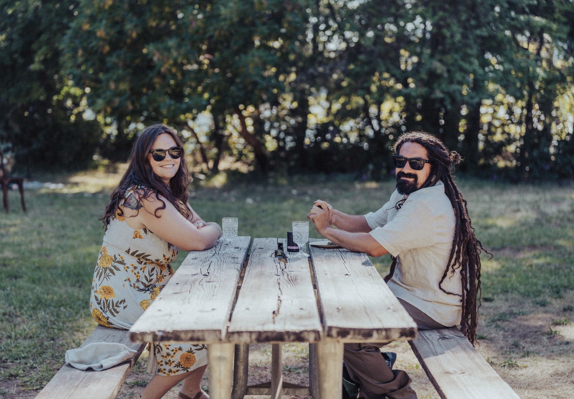 A man and a woman are sitting at a picnic table.