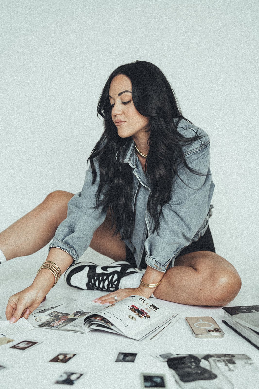 A woman is sitting on the floor looking at pictures.