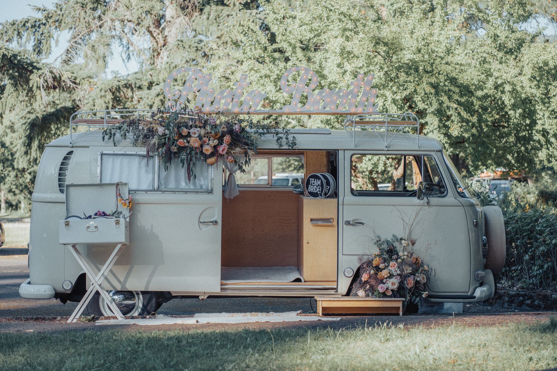 A white van with flowers on the side is parked in a field.