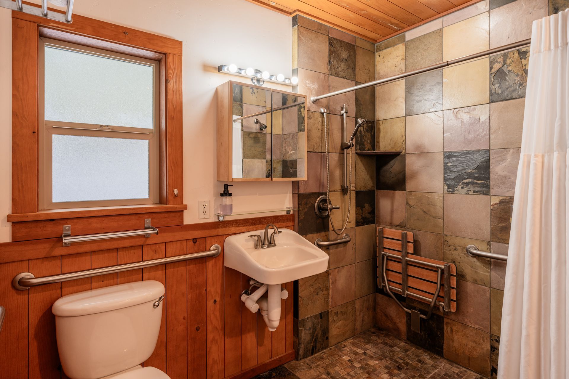 A bathroom with a toilet , sink , and shower.