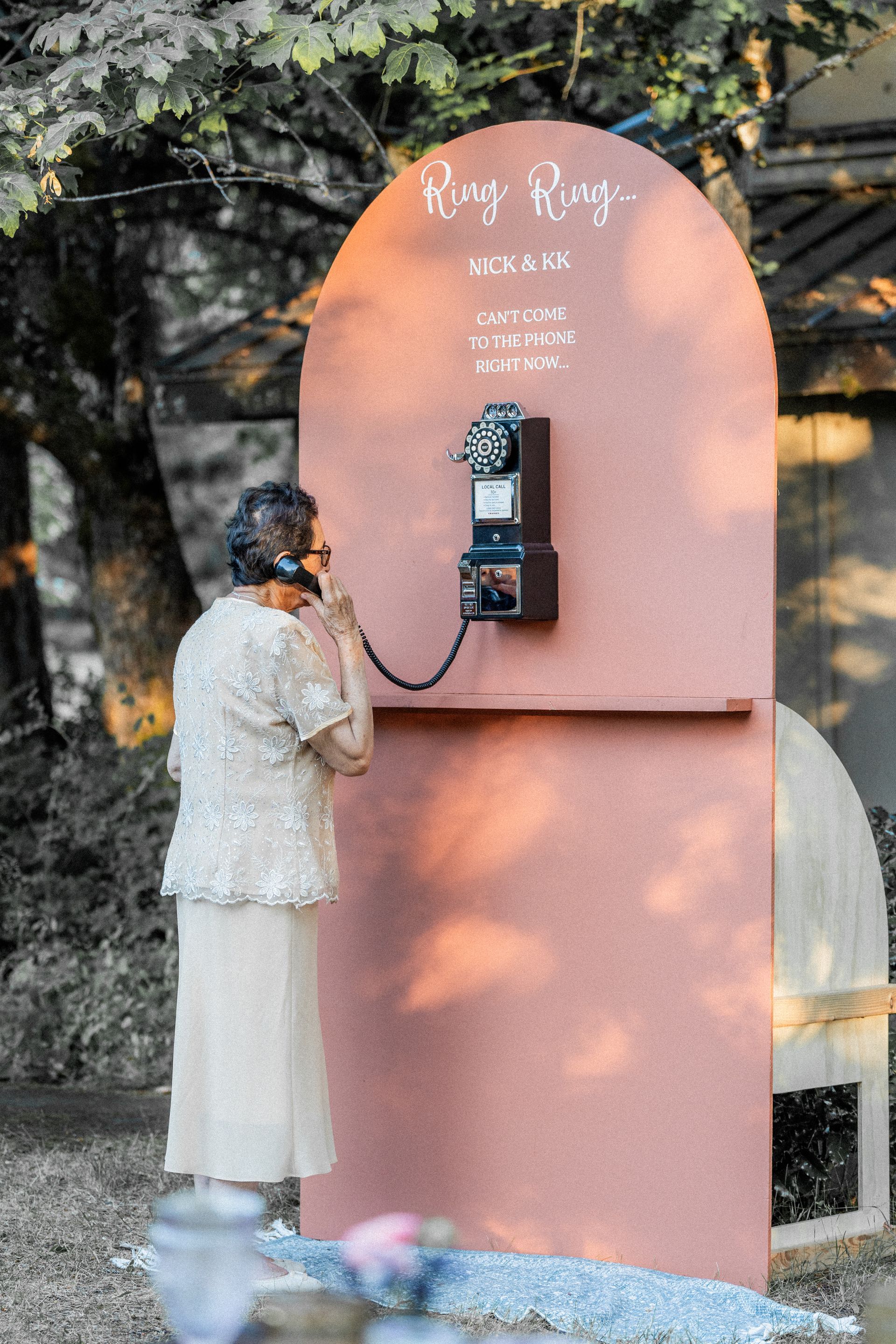 A woman is talking on a pay phone.