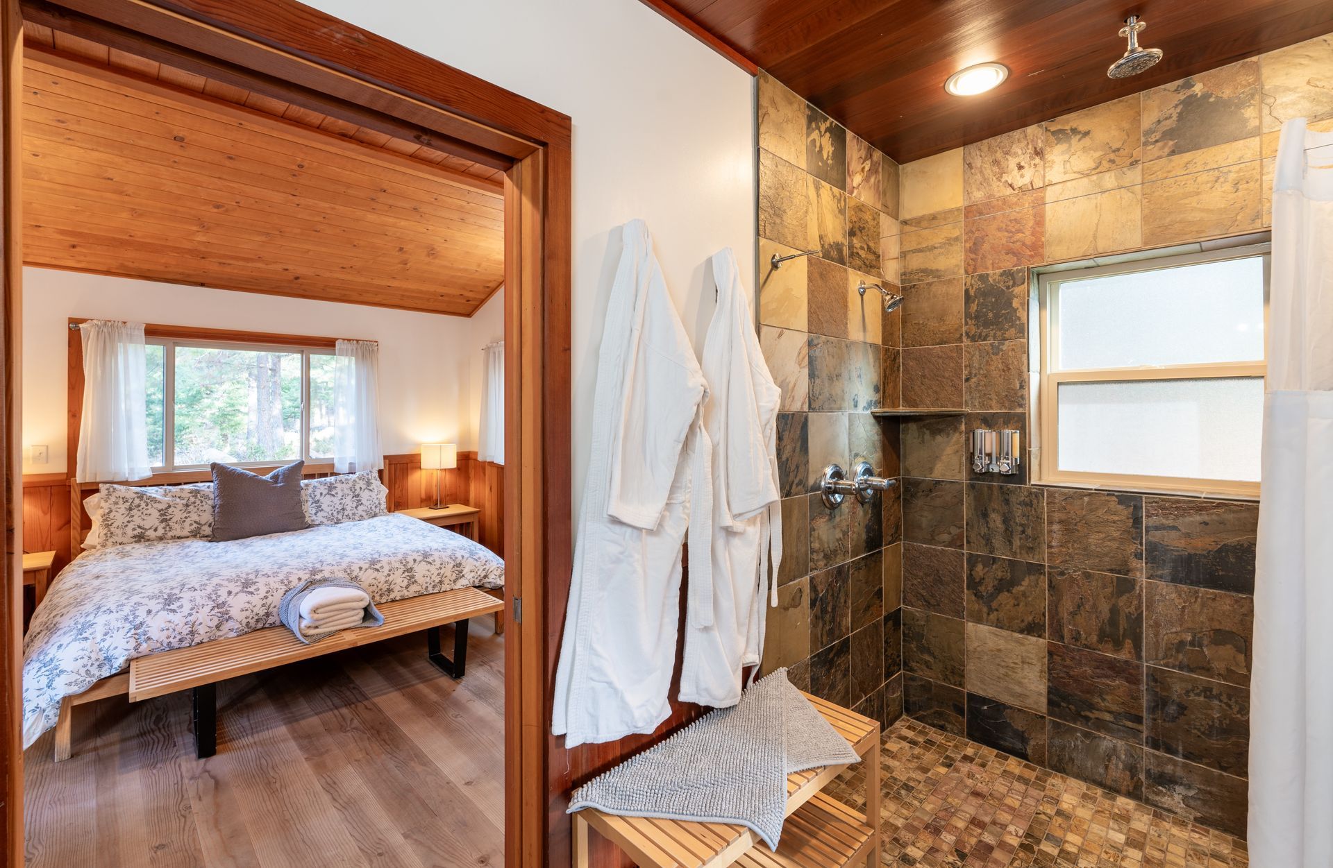 A bedroom with a king size bed and a walk in shower.