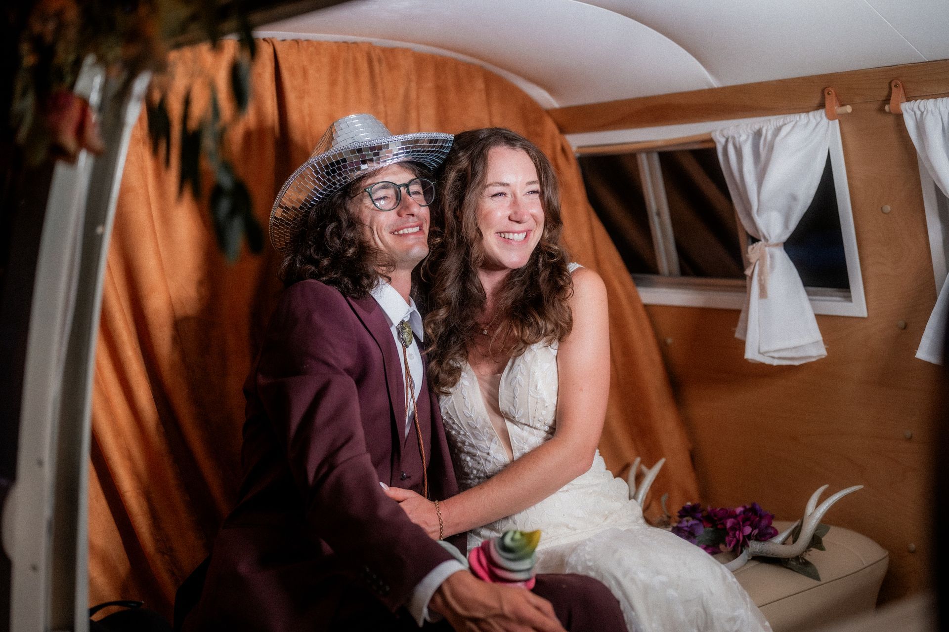 A bride and groom are posing for a picture in a photo booth.