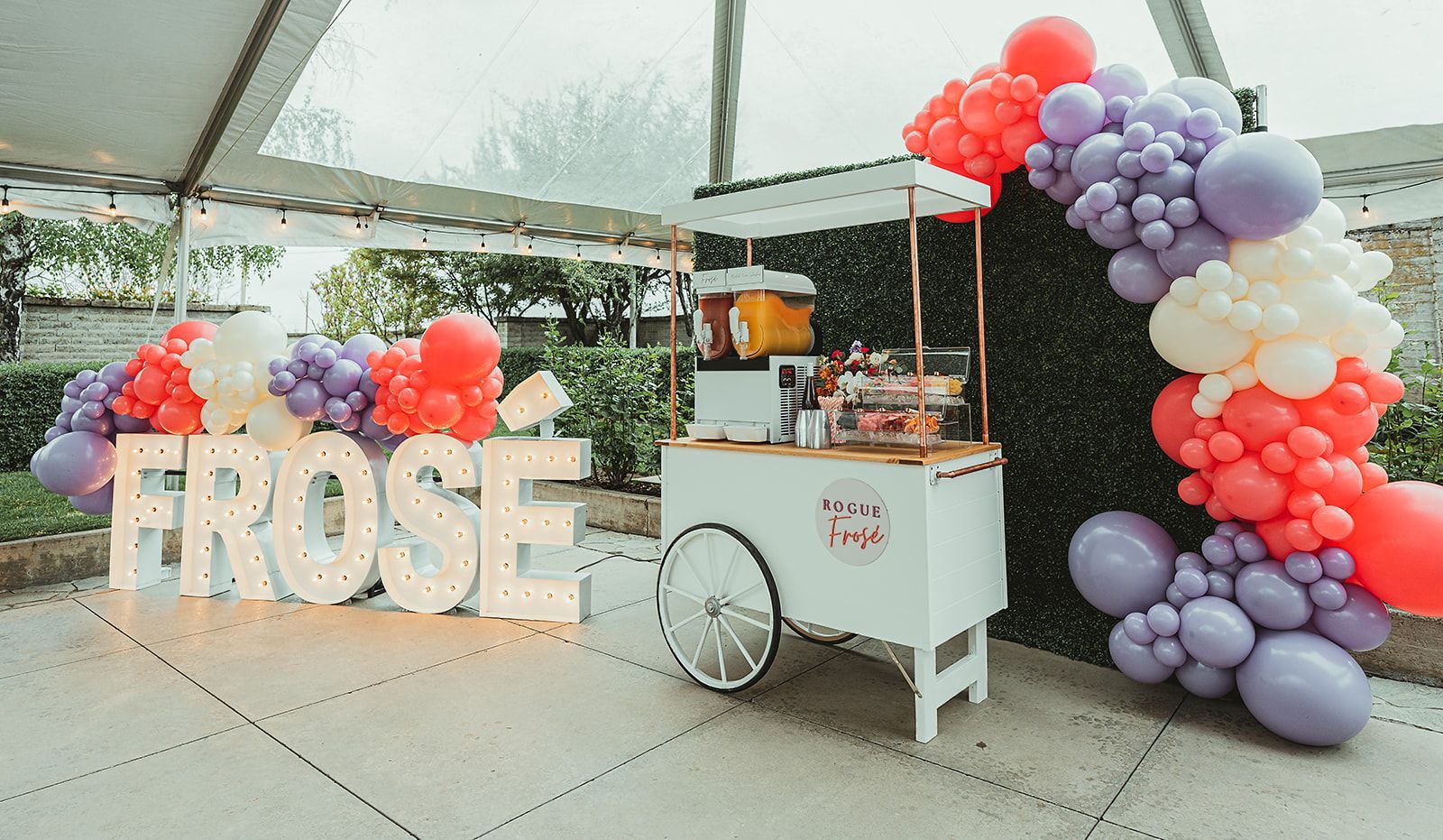 A cart is decorated with balloons and a sign that says frose.