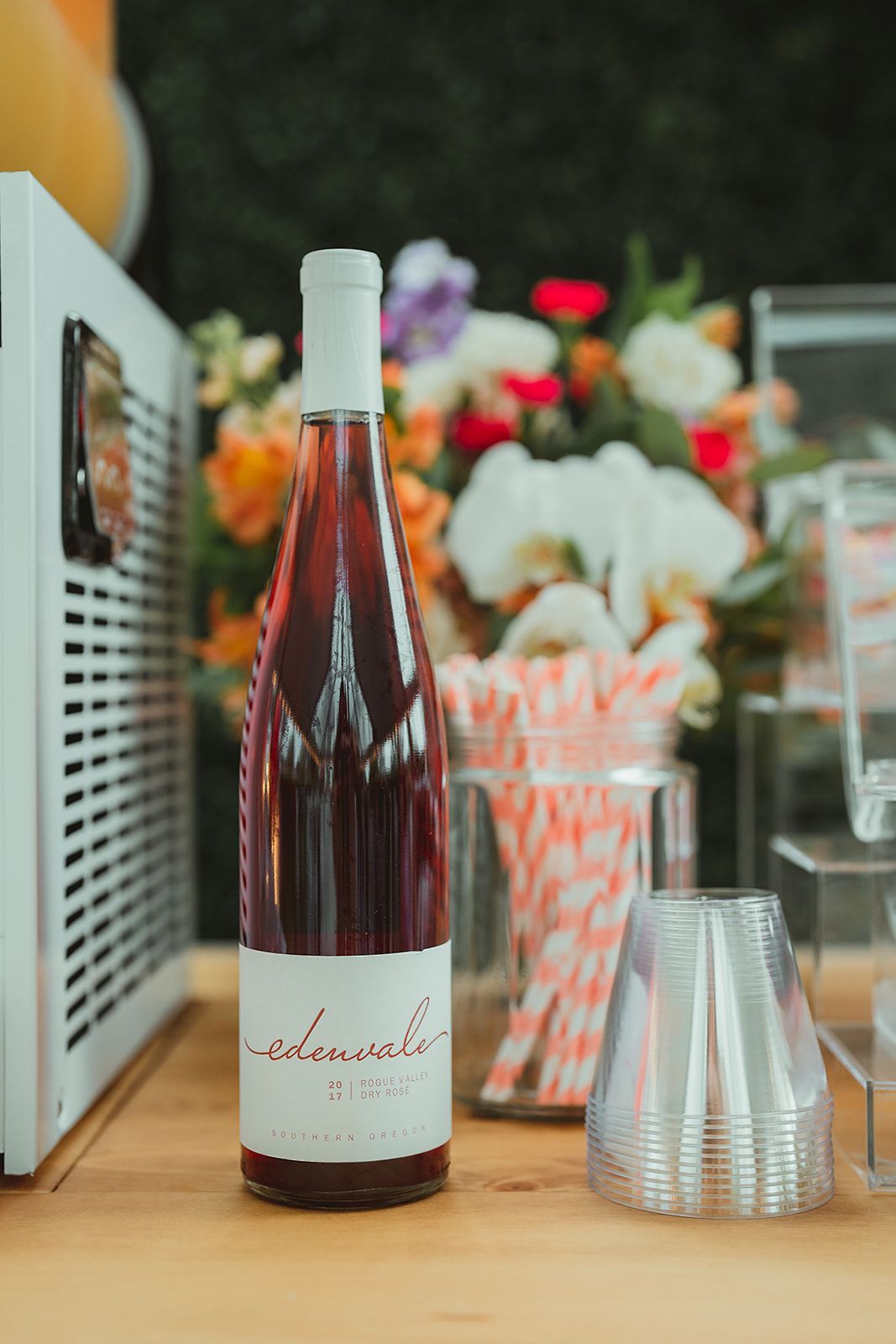 A bottle of wine is sitting on a wooden table.