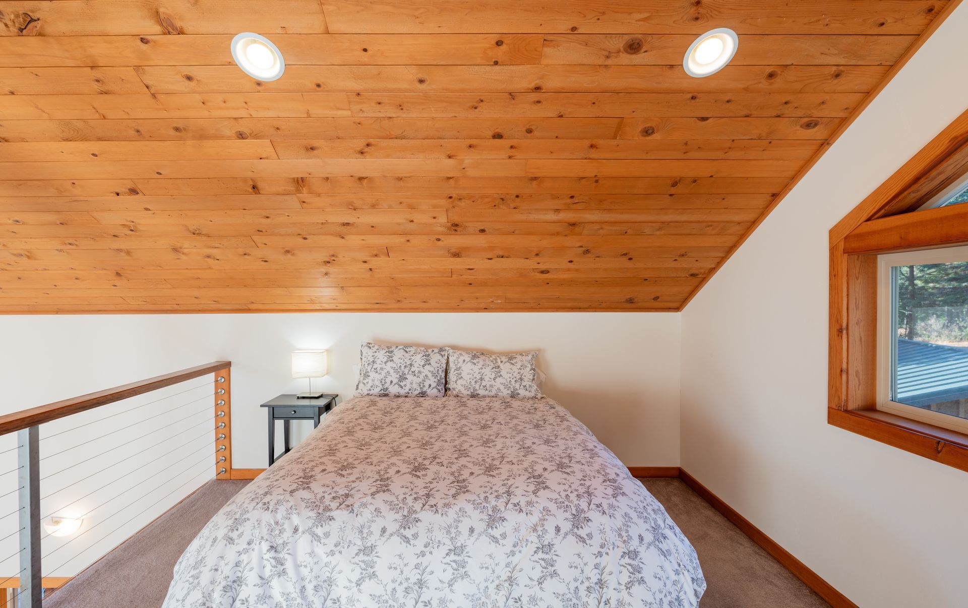 A bedroom with a wooden ceiling and a bed