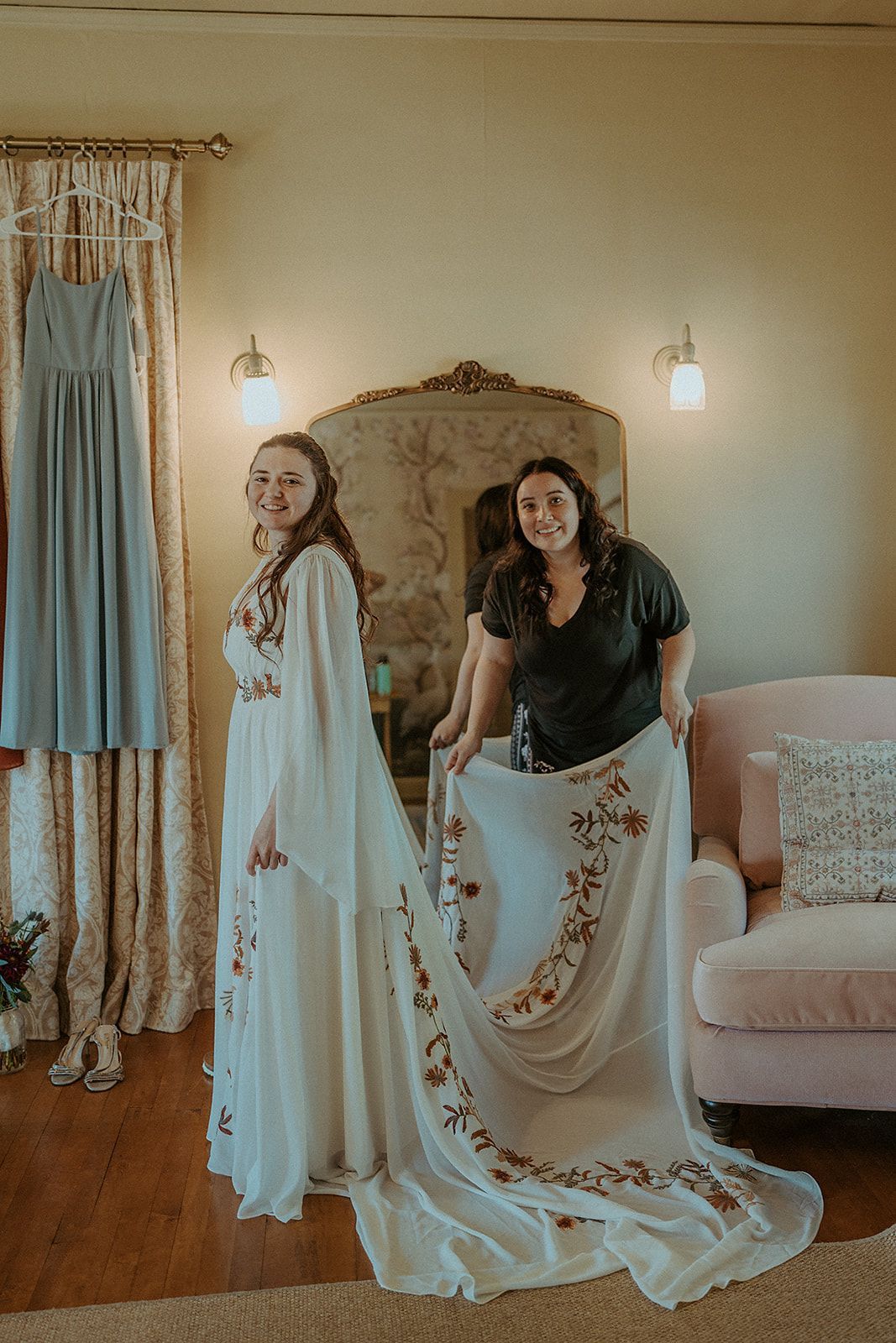 Two women in wedding dresses are standing next to each other in a room.