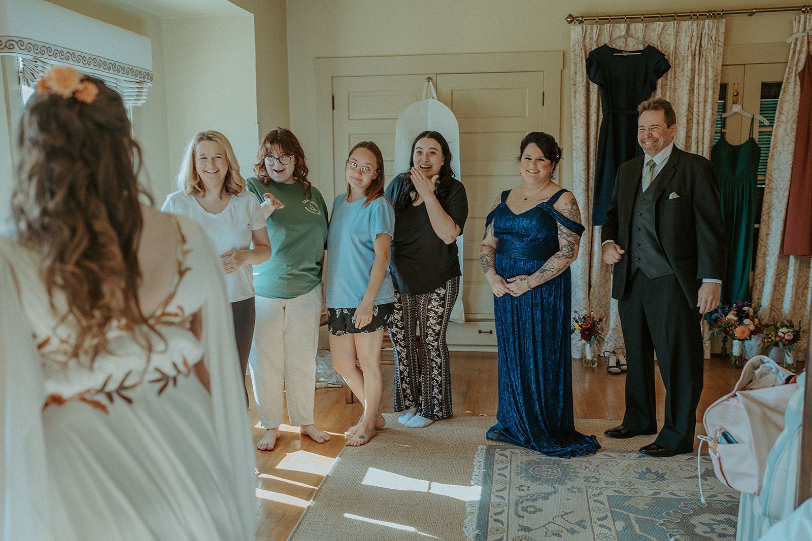 A group of people are standing around a woman in a wedding dress.
