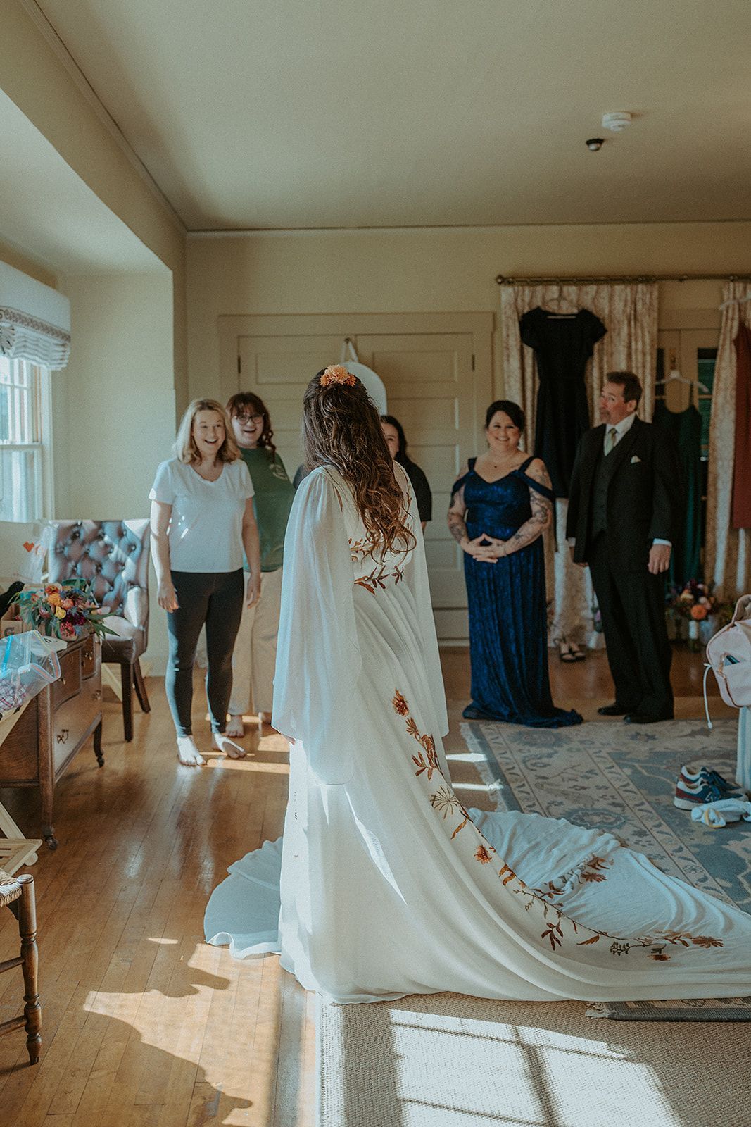 A bride is getting ready for her wedding in a room with her family.