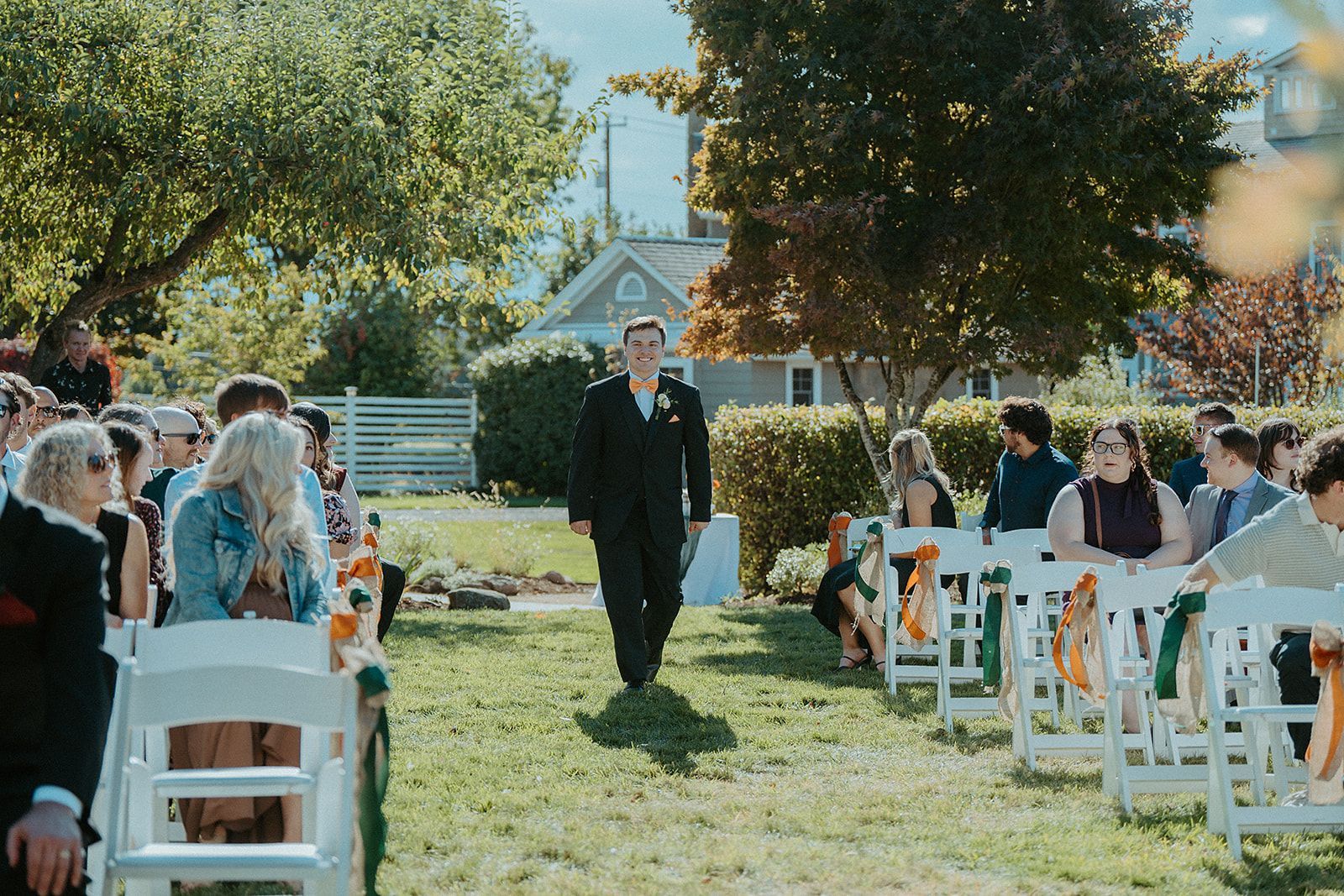 A groom is walking down the aisle at a wedding.