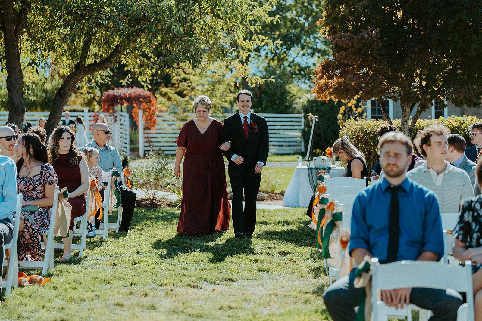 A group of people are sitting in chairs watching a wedding ceremony.