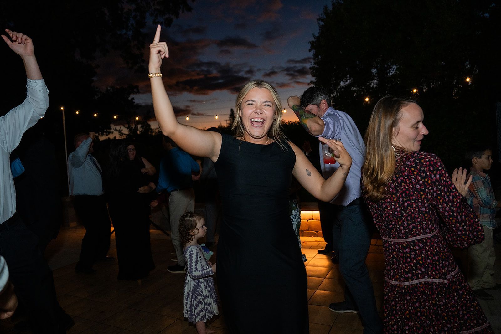 A group of people are dancing at a wedding reception.