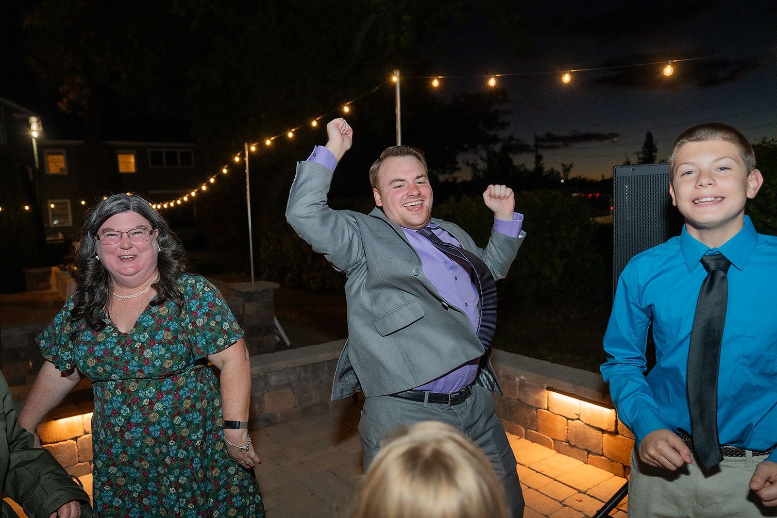 A group of people are dancing together at a wedding reception.
