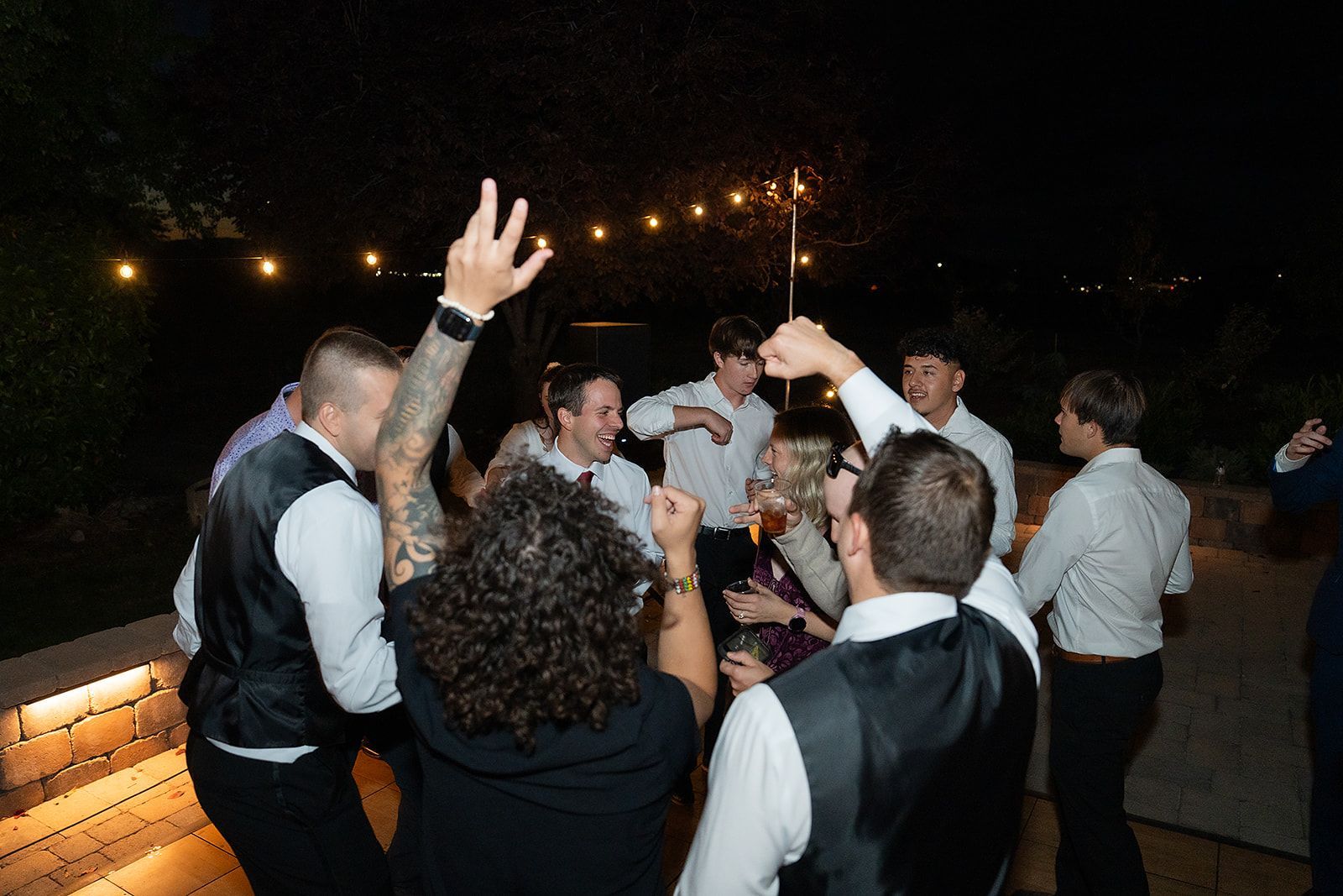 A group of people are dancing at a wedding reception.