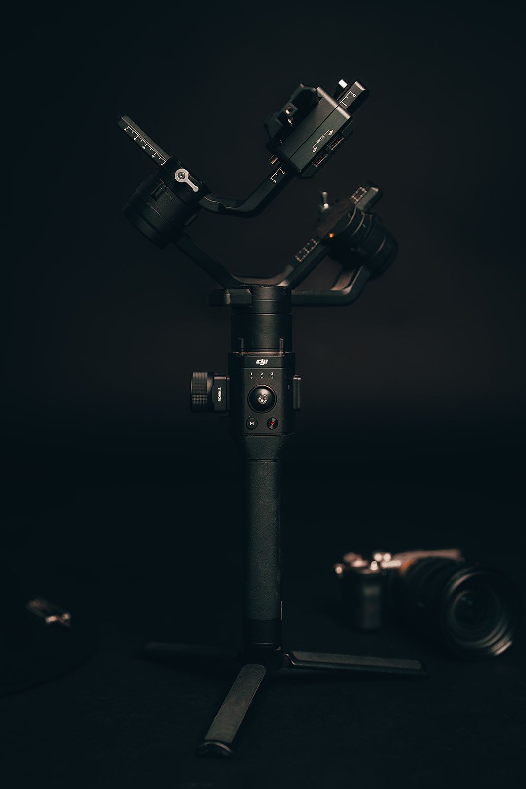 A camera is sitting on top of a gimbal in the dark.