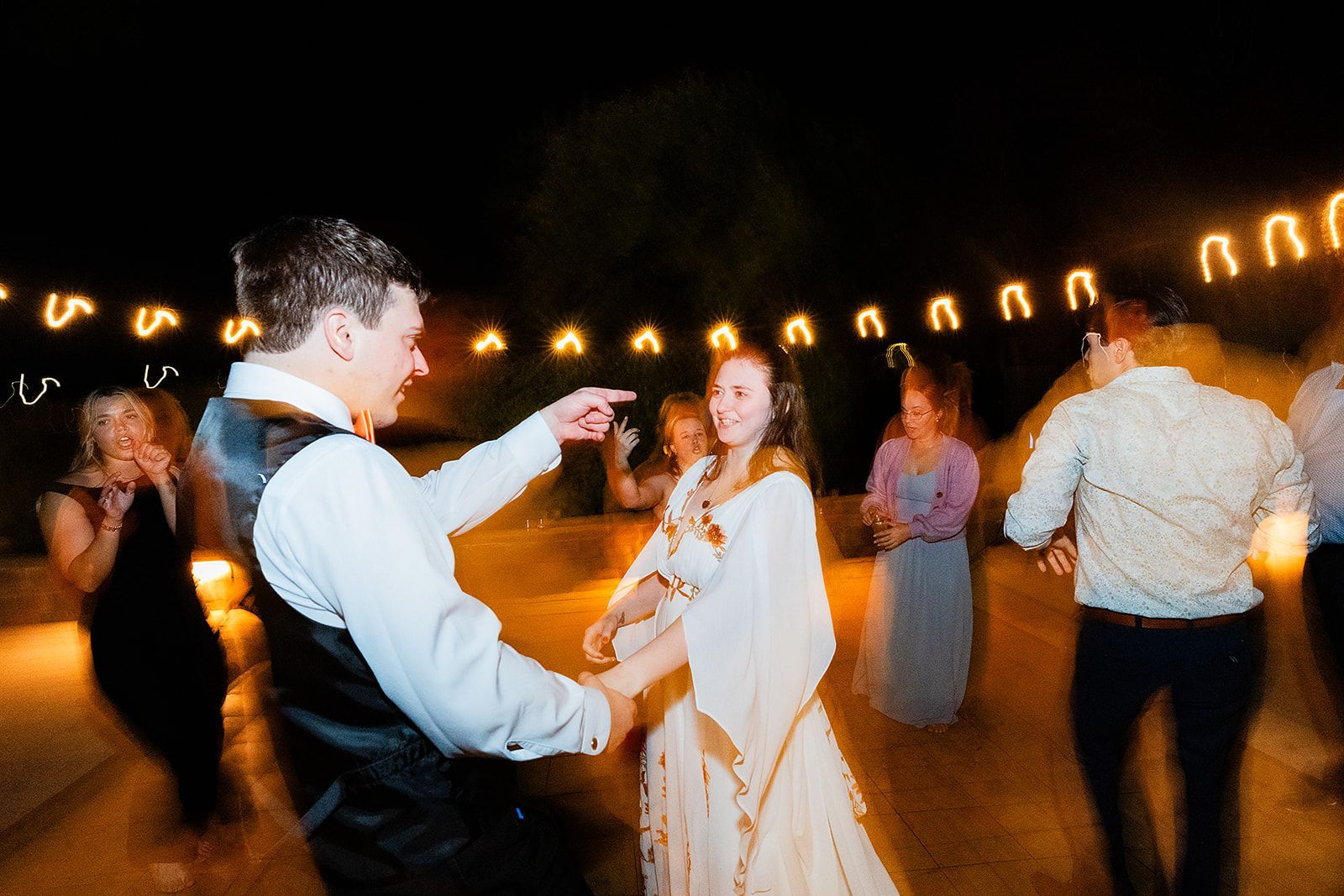 A bride and groom are dancing at a wedding reception.