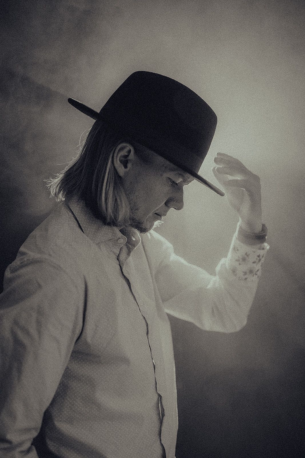 A black and white photo of a man wearing a hat.
