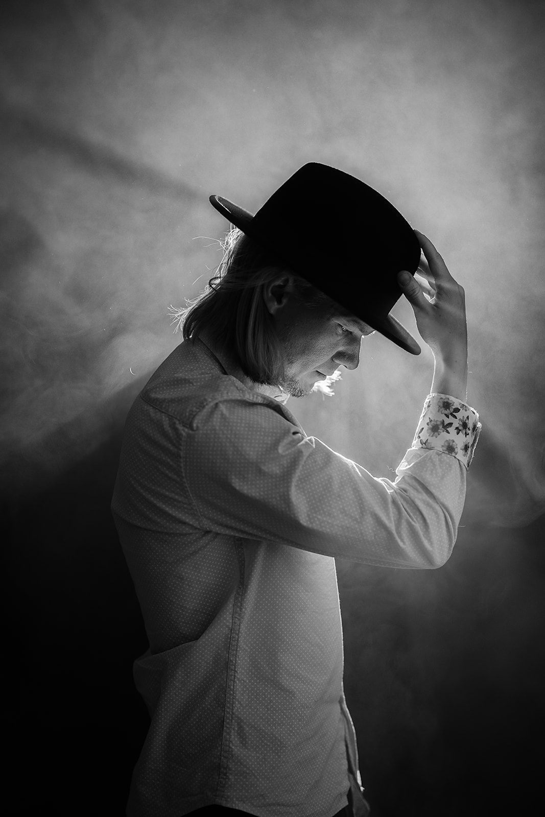 A black and white photo of a man wearing a hat.