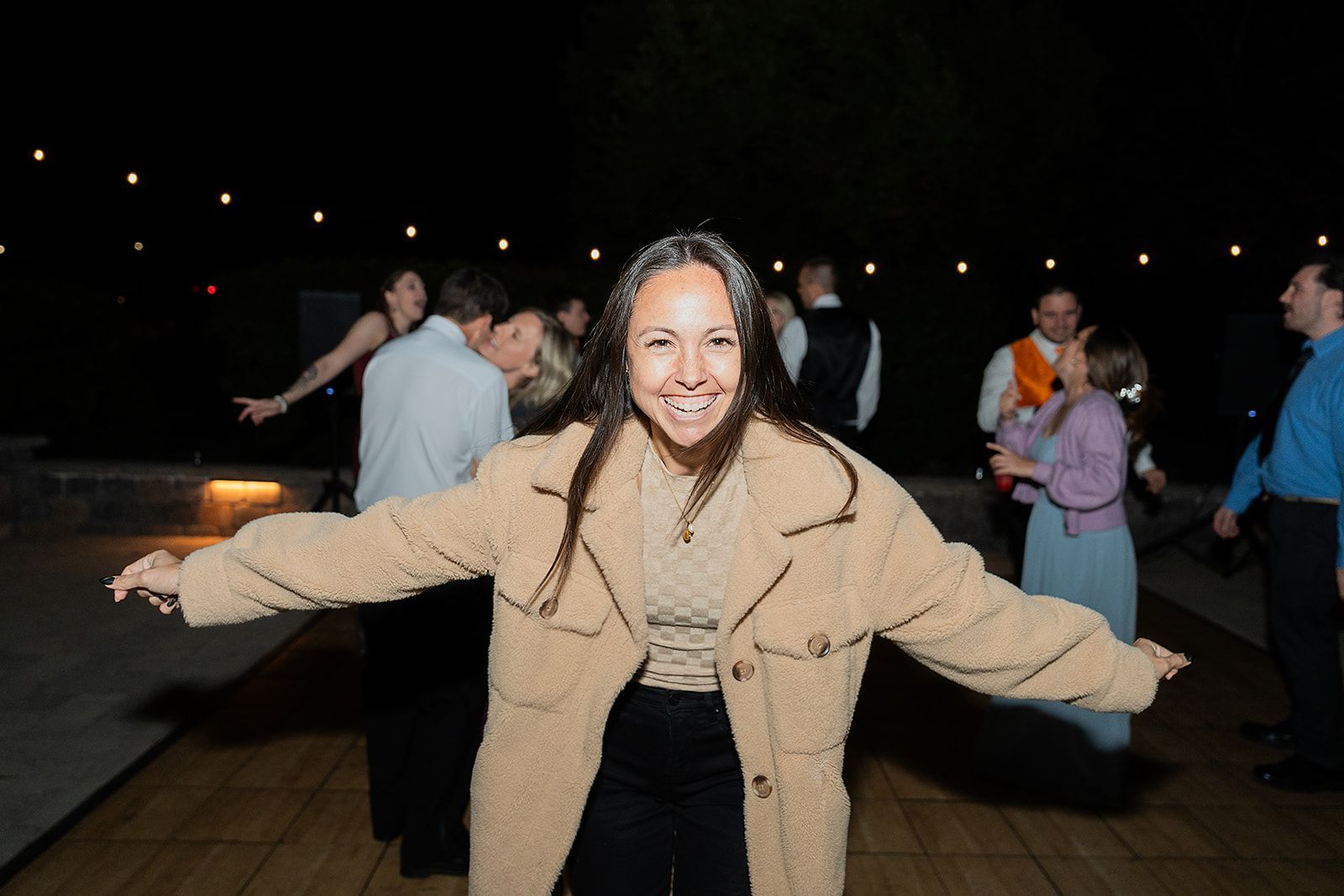 A woman is dancing on a dance floor with her arms outstretched.