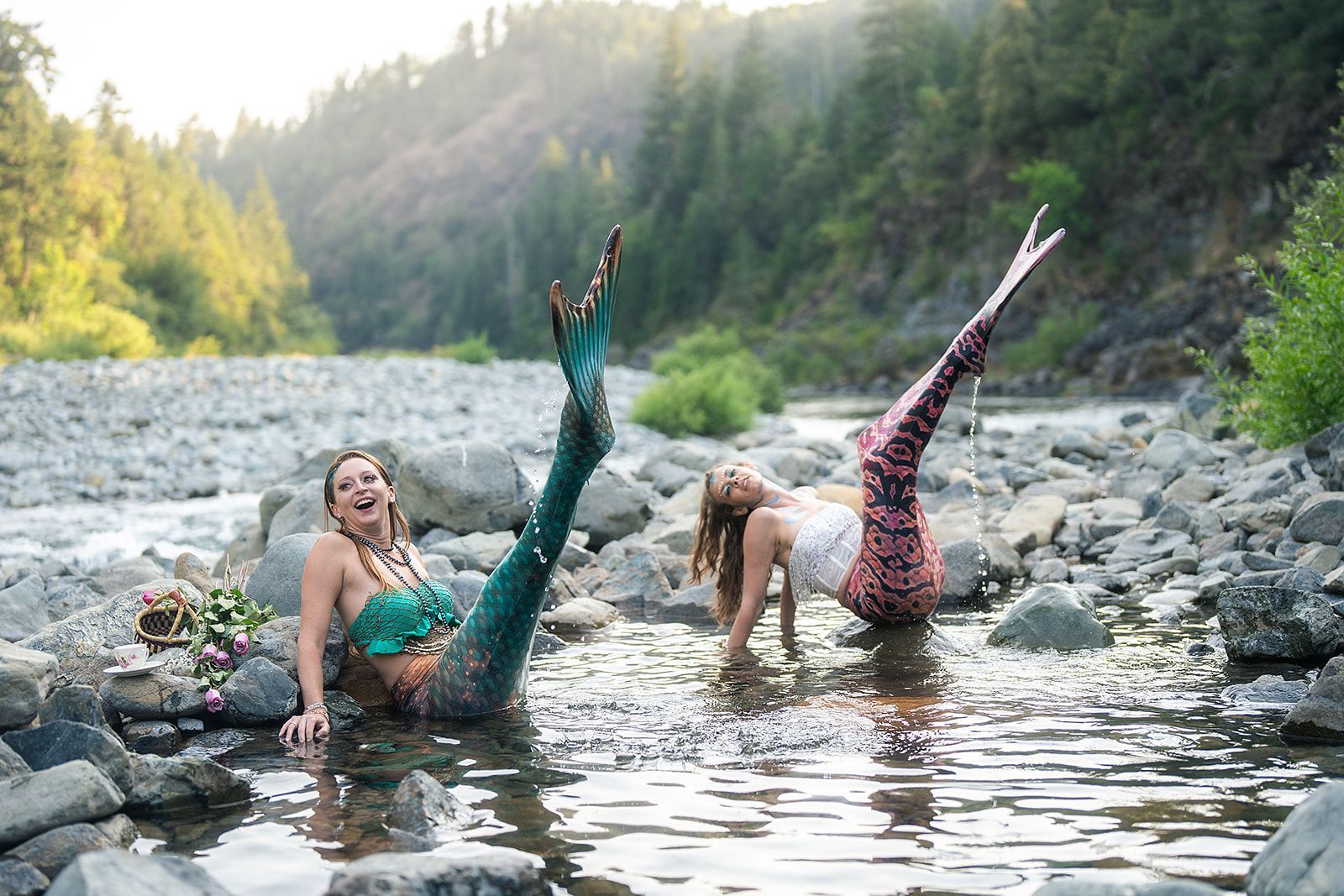Two mermaids are playing in a river.